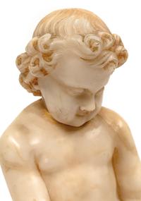A Continental Carved Marble Figure of a Putto on a Red Marble Base