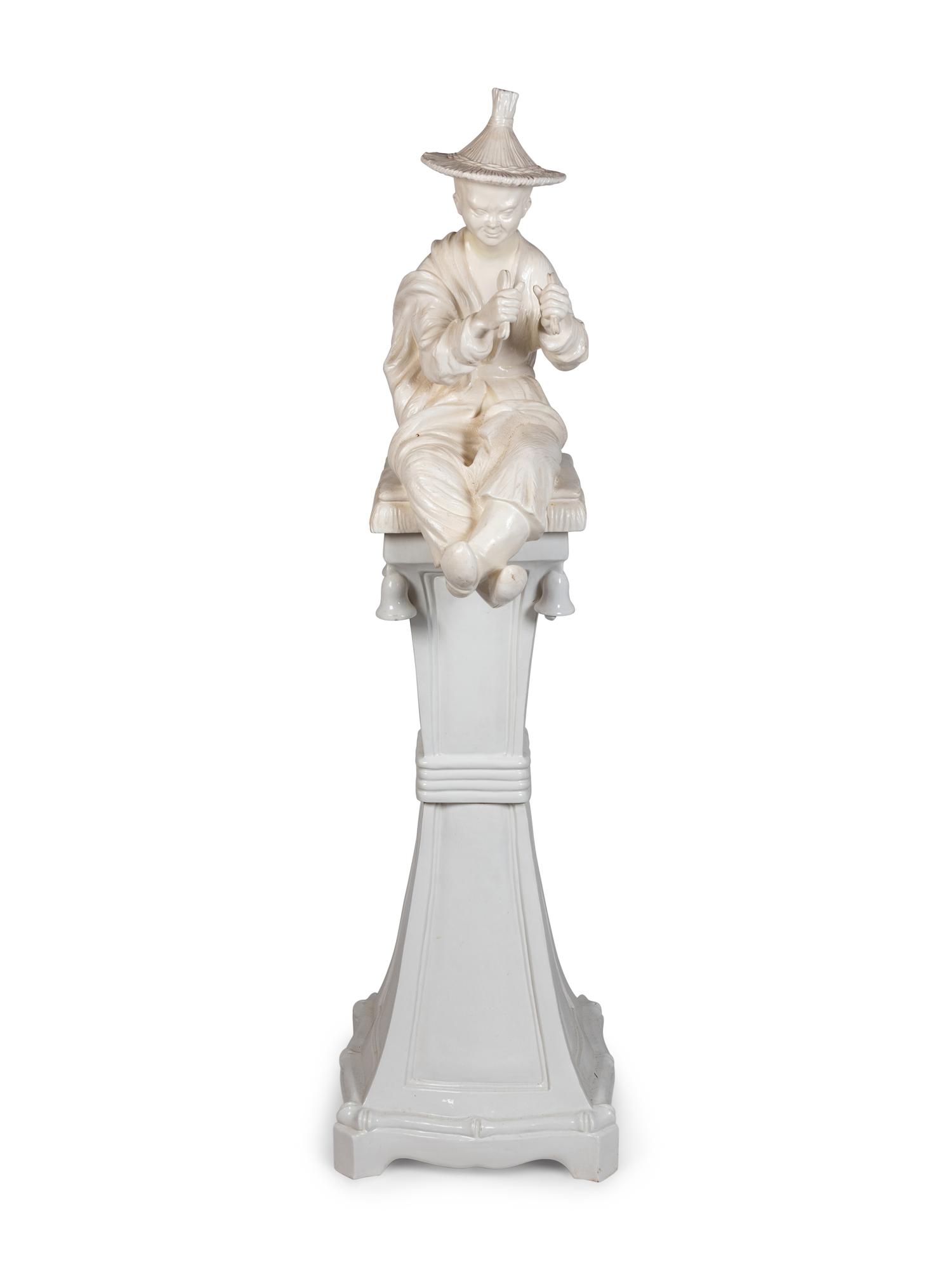 A Continental Blanc de Chine Figure of a Seated Chinese Man on a Pedestal