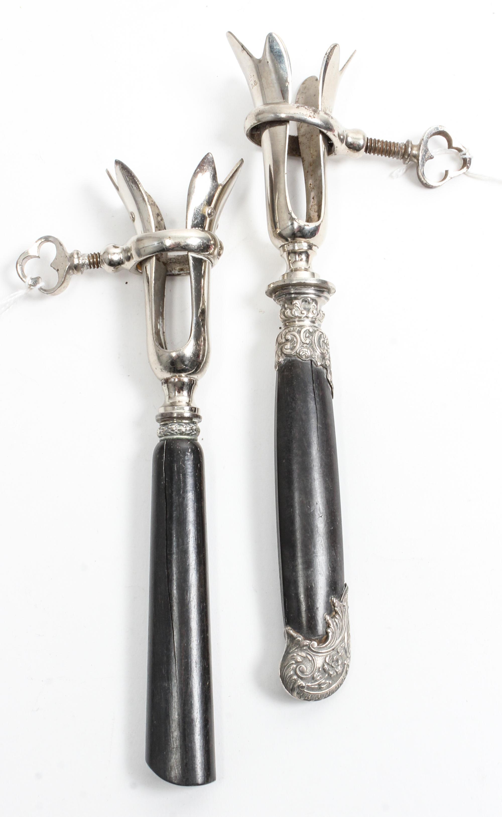 Two French Silver Mounted Bone Holders, makers' marks obscured, each having an ebony handle and a silvered metal clamp.