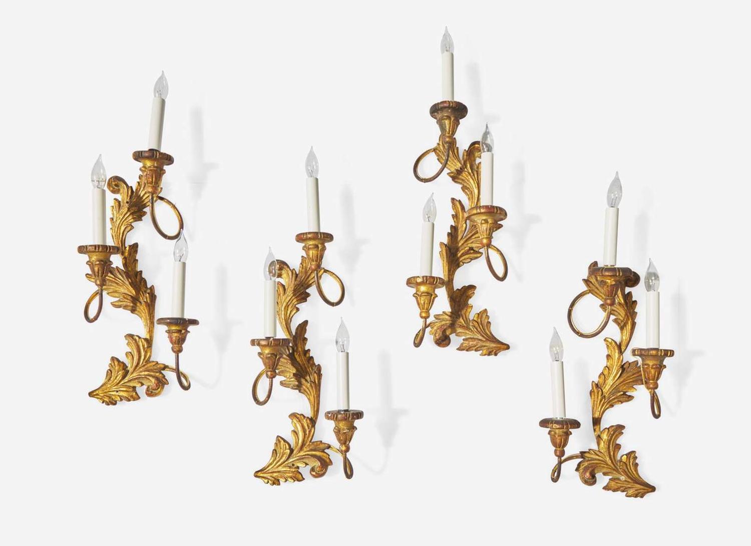 A set of four Rococo style giltwood and metal three-light sconces, 20th century