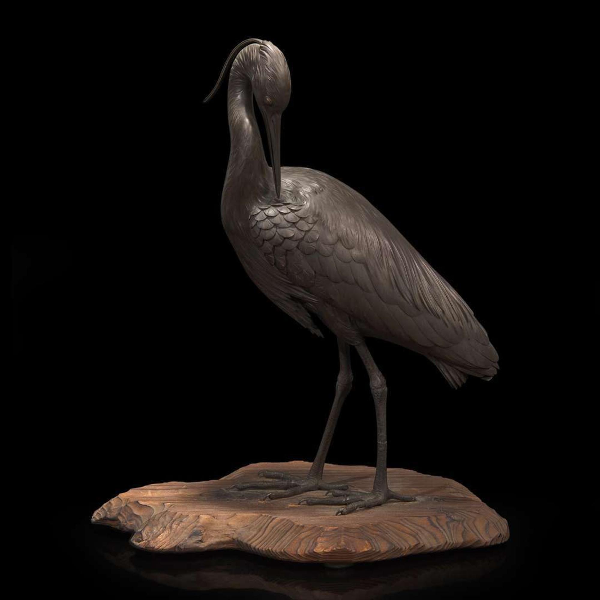 A Japanese patinated bronze figure of a preening heron, signed Kuniharu 日本鹭鸶铜塑 斉木 Meiji / Taisho ?????
