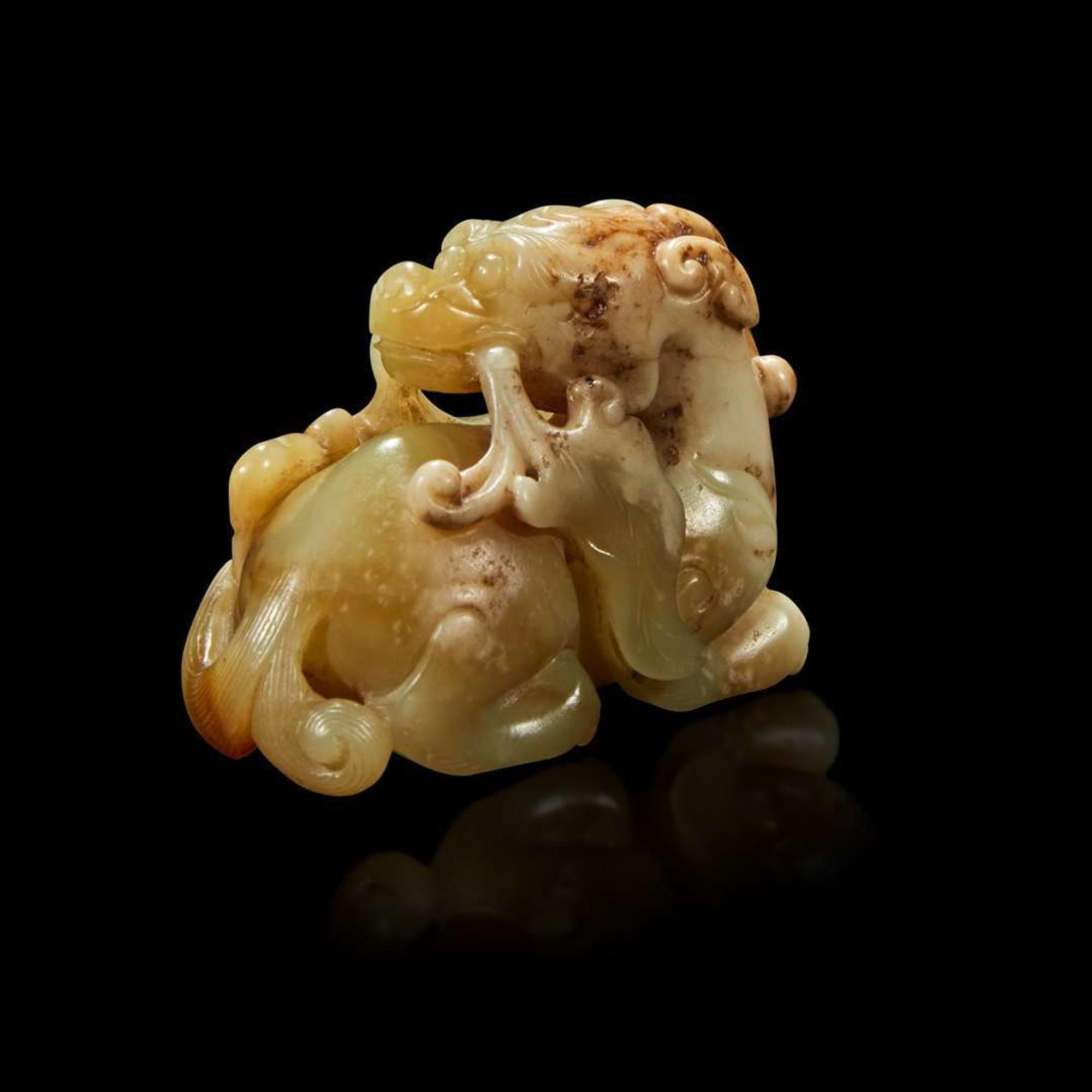 A Chinese small celadon, beige and russet jade figure of a mythical beast Qing Dynasty, 18th Century or earlier