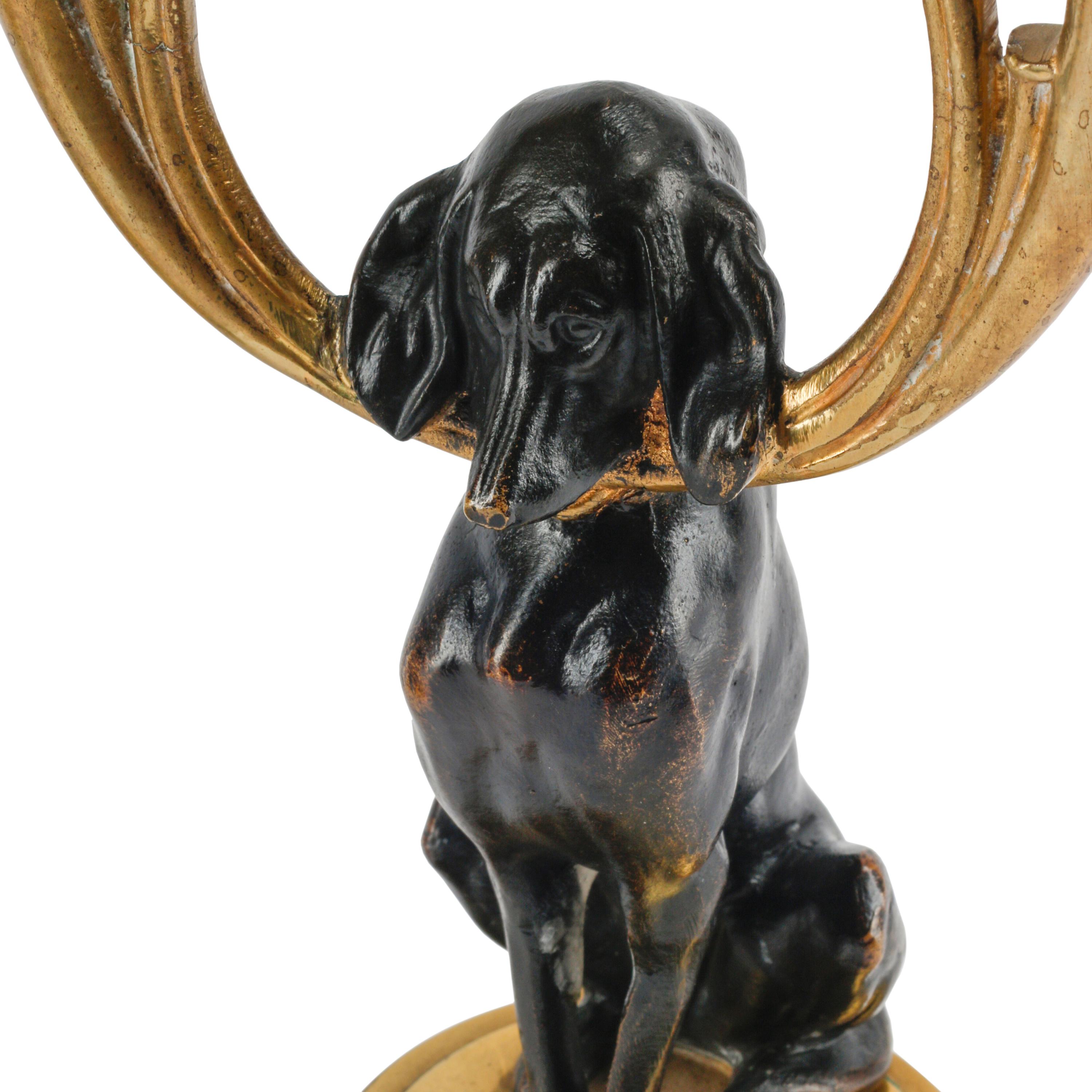 A Pair of Gilt and Patinated Bronze Dog Motif Two-Light Candelabra