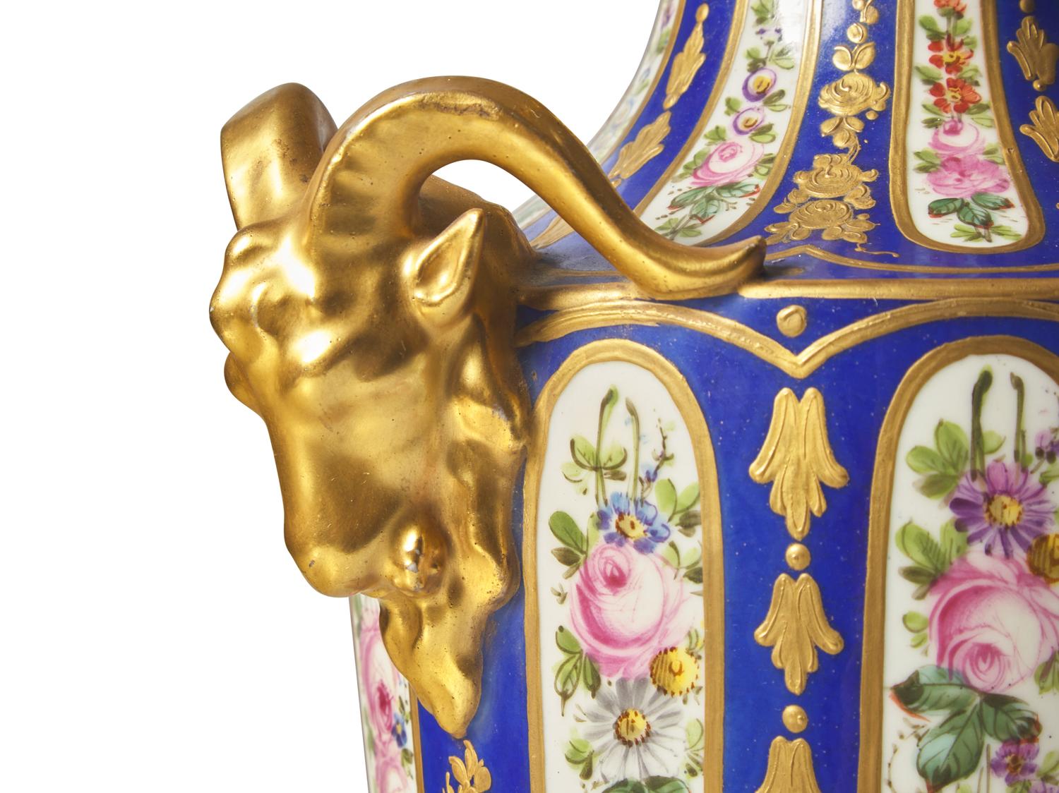 A Pair of Sevres Parcel Gilt, Cobalt and Garland Decorated Porcelain Lidded Urns