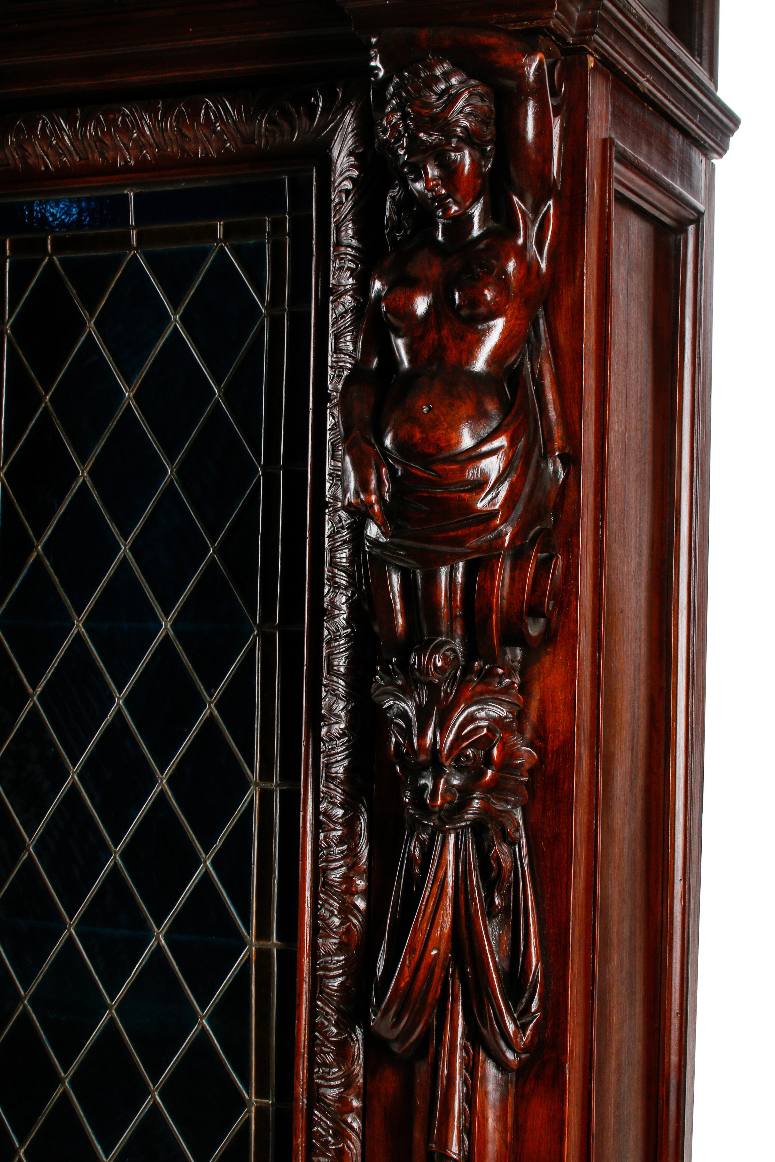 A Continental Renaissance Revival Carved Walnut and Leaded Glass Cabinet