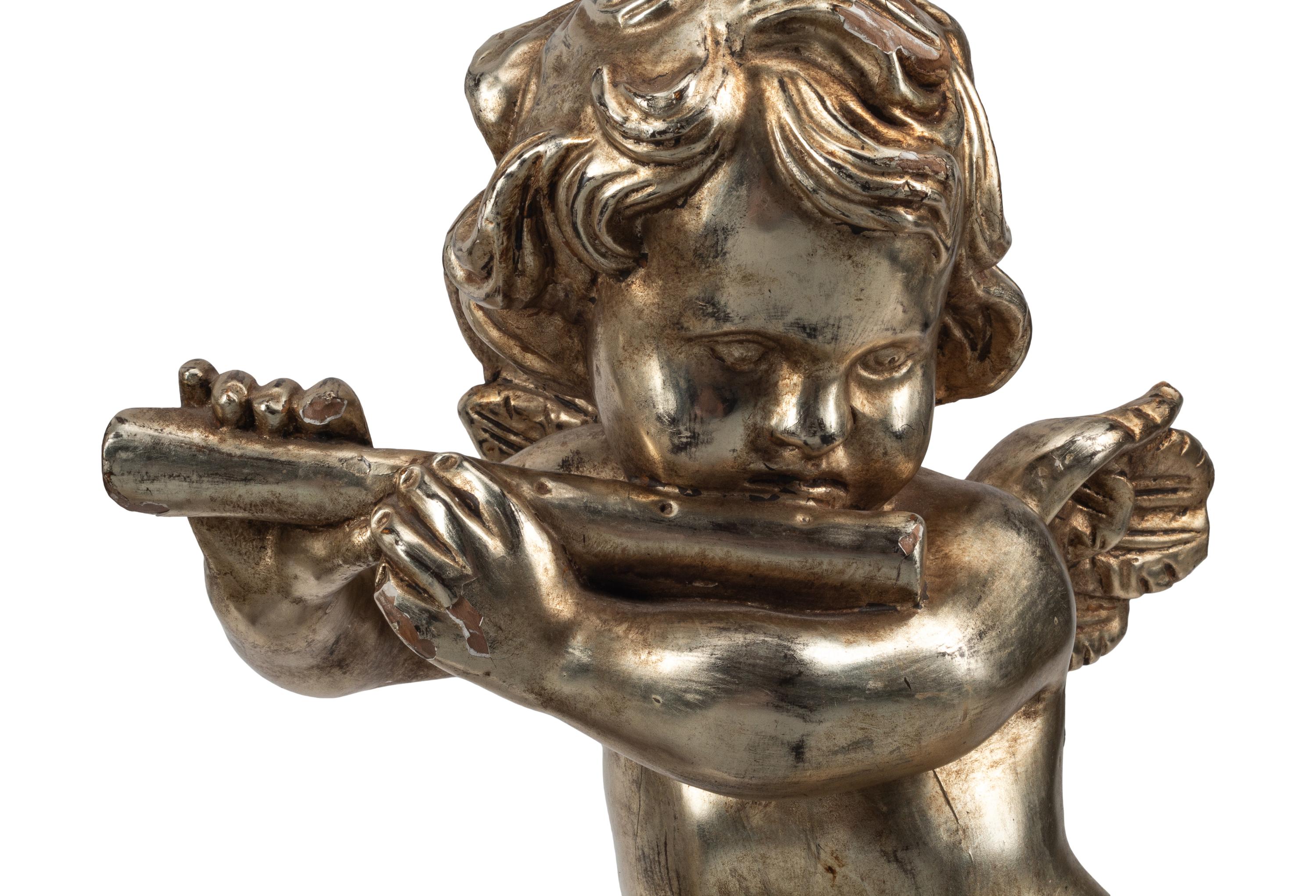 A Pair of Silvered Wood Musical Putto Ornaments