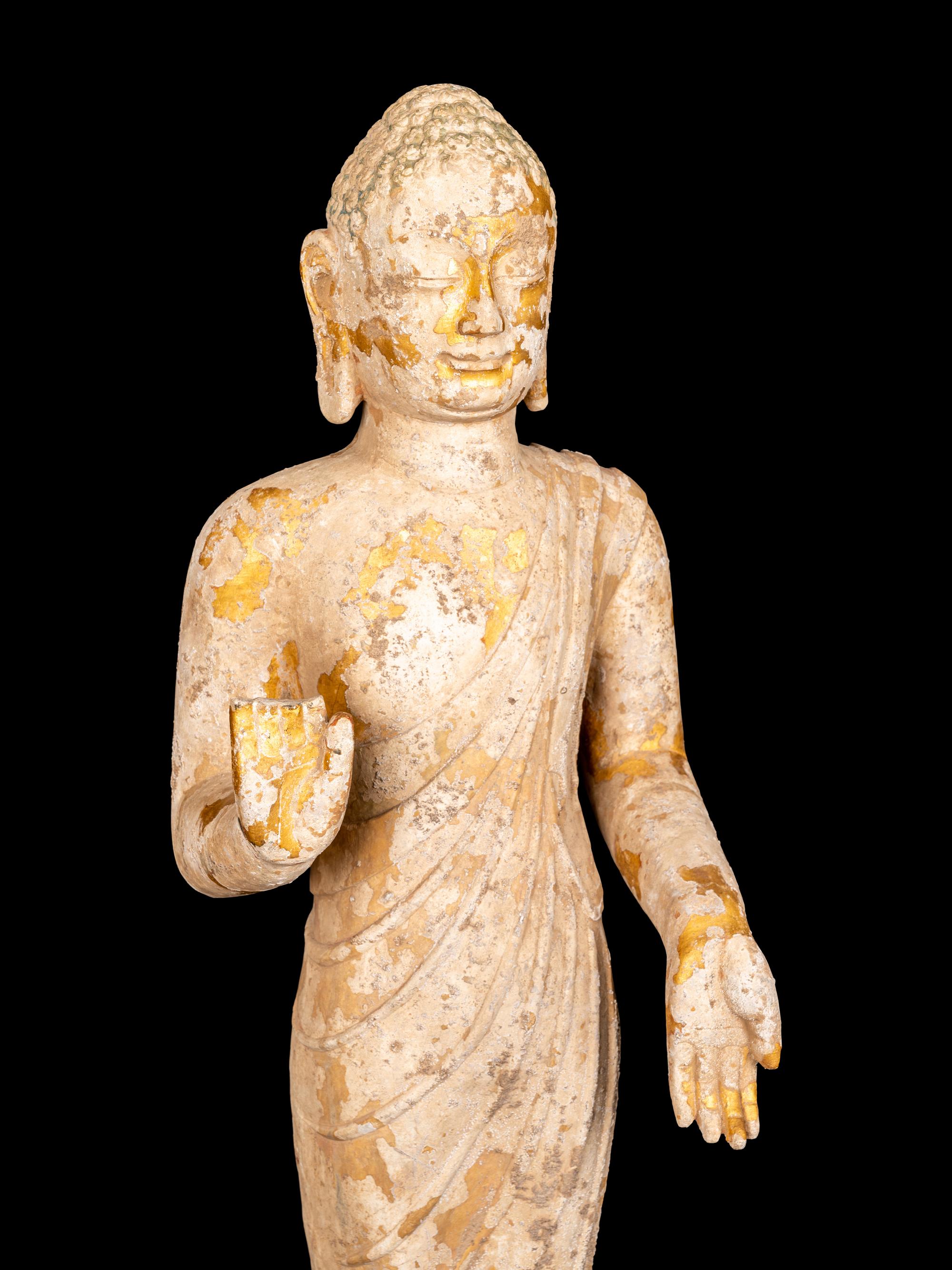 A Chinese Carved Stone Standing Draped Guanyin Figure with Remnants of Gilt on Surface