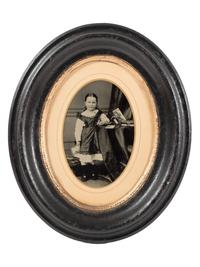 [EARLY PHOTOGRAPHY]. Tintype portrait of a little girl posed with stereoviews, viewer, and photo album.