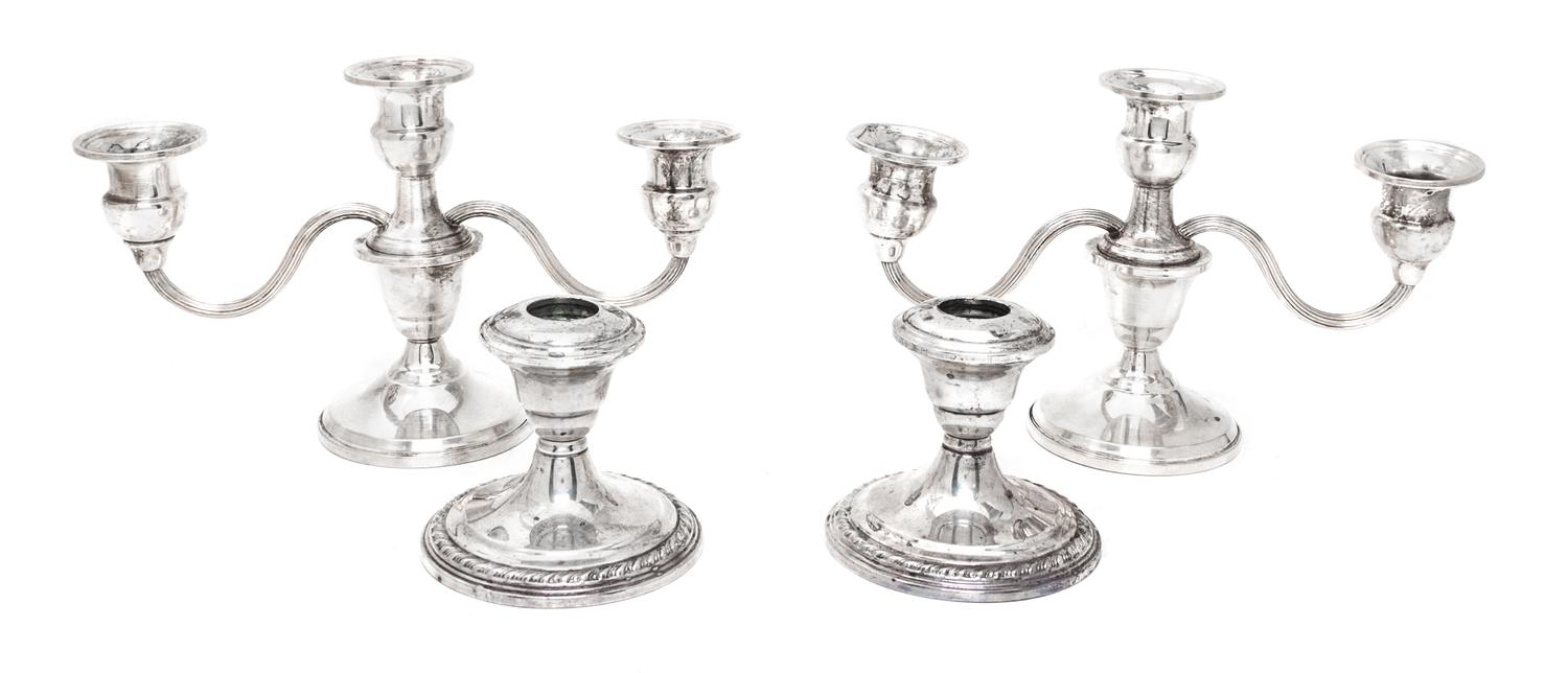 Two Pairs of Weighted Sterling Candlesticks, Various Makers, comprising a pair of three-light candlesticks and a pair of single light c
