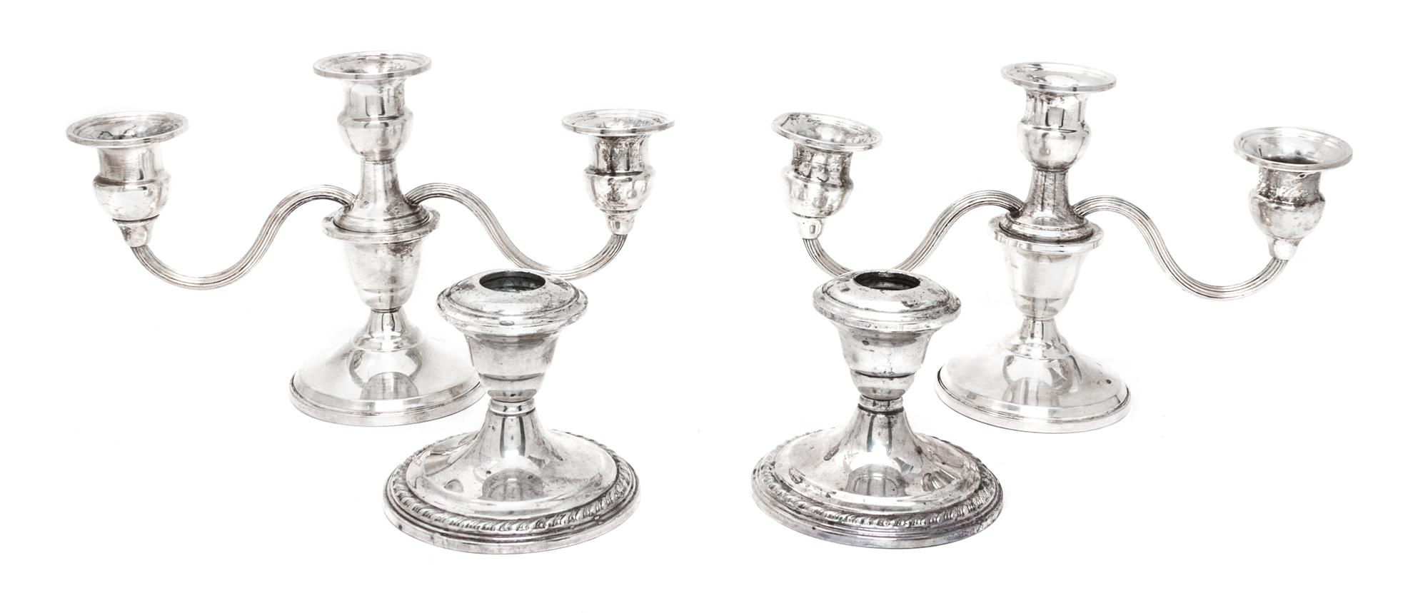 Two Pairs of Weighted Sterling Candlesticks, Various Makers, comprising a pair of three-light candlesticks and a pair of single light c