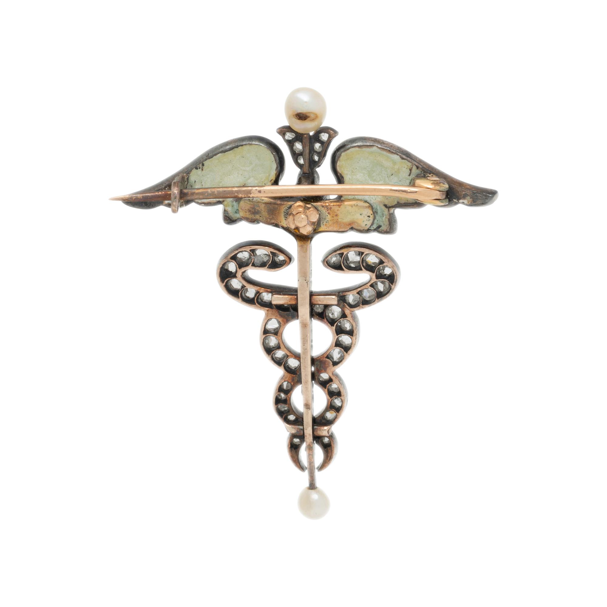 ART NOUVEAU, DIAMOND, SEED PEARL, DEMANTOID GARNET, AND ENAMEL CADUCEUS BROOCH