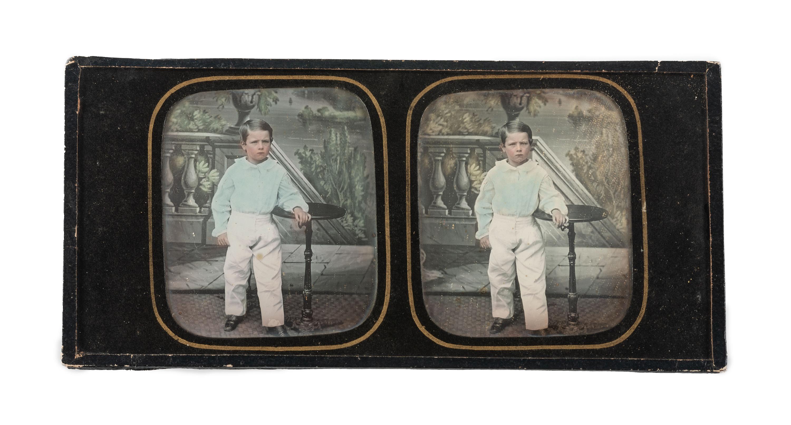 [EARLY PHOTOGRAPHY]. Hand-tinted stereodaguerreotype featuring a young boy standing next to a candlestand.