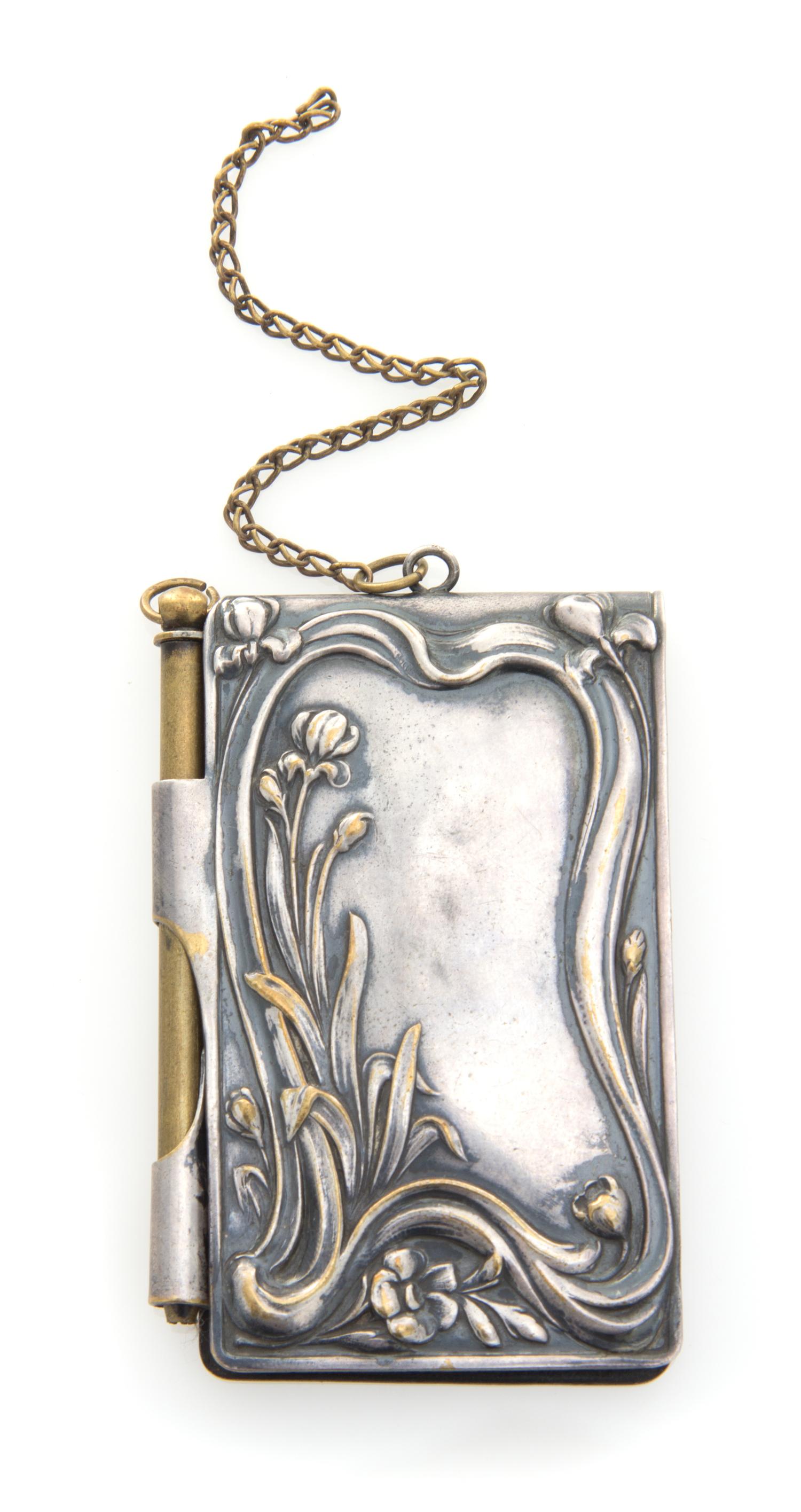 A Continental Silver Chatelaine Notepad, , the case worked to show flowering branches and opening to a partial sheet of stamp-cut paper