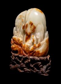 A Chinese Celadon and Russet Jade 'Landscape' Boulder