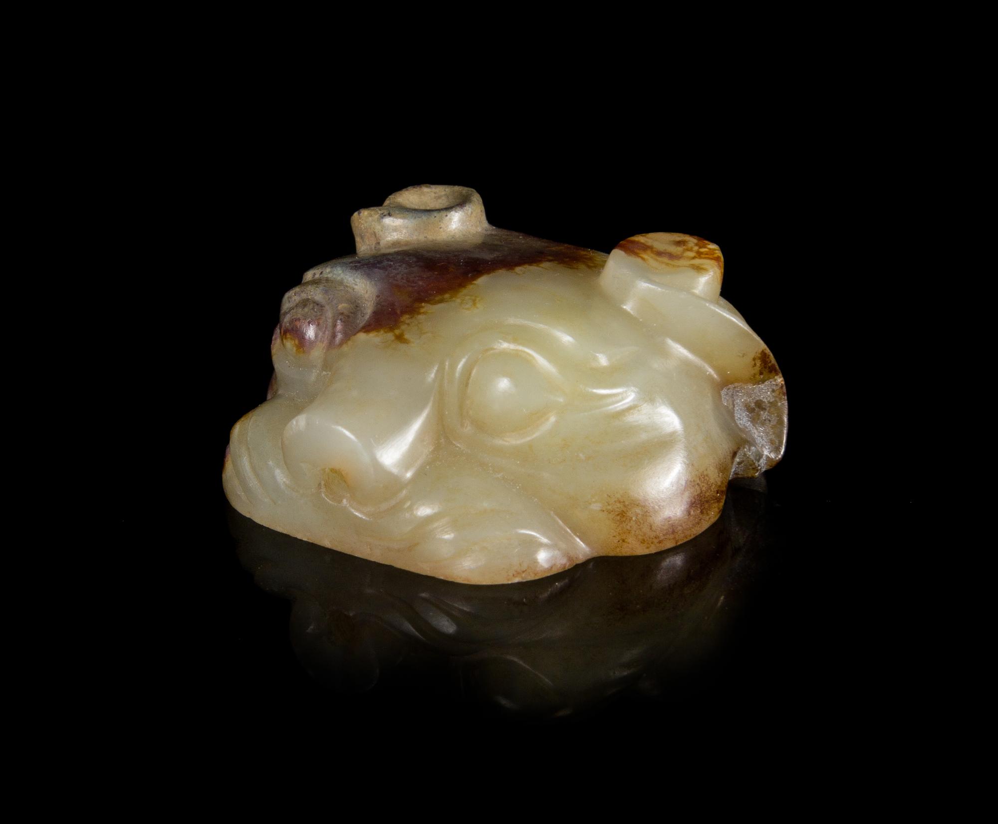 A Pale Celadon and Russet Jade Mask Length 1 1/8 inches.