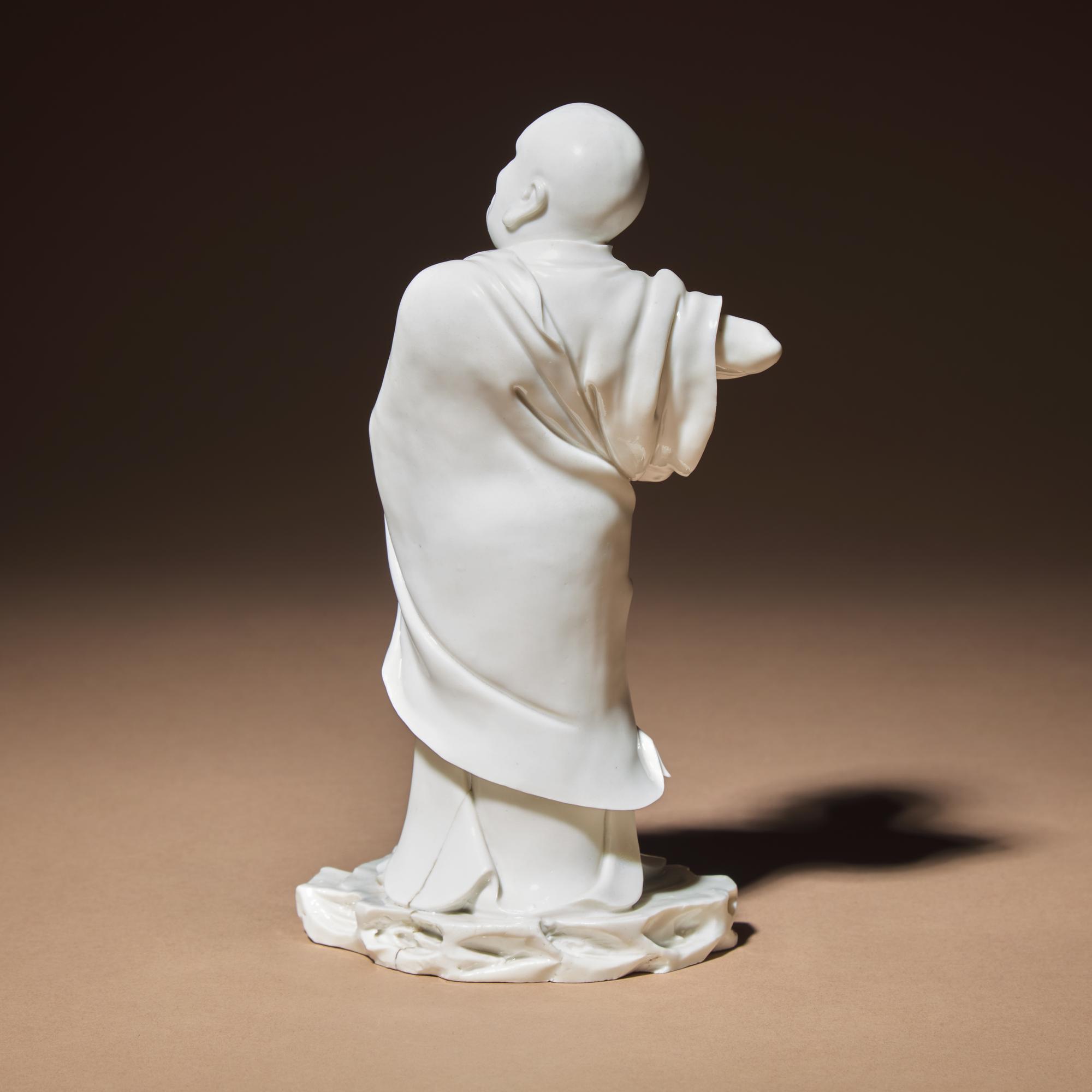 A Chinese Blanc-de-Chine Porcelain Standing Figure of a Luohan, Qing Dynasty — 清 德化白瓷羅漢立像