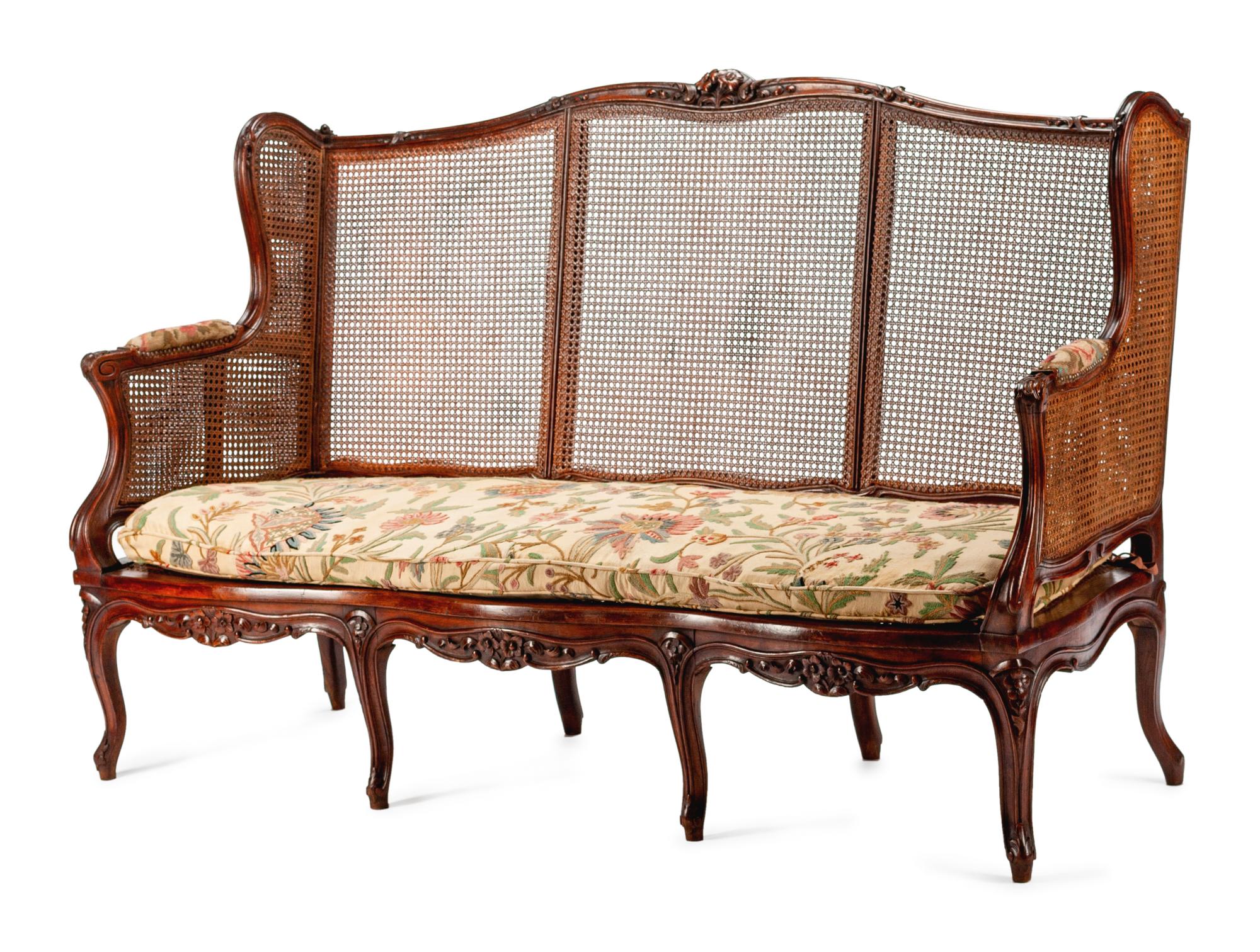 A French Provincial Carved Oak and Caned Settee