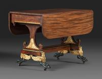 A Classical Parcel Gilt and Ebonized, Figured Mahogany Paw-Foot Drop-Leaf Table