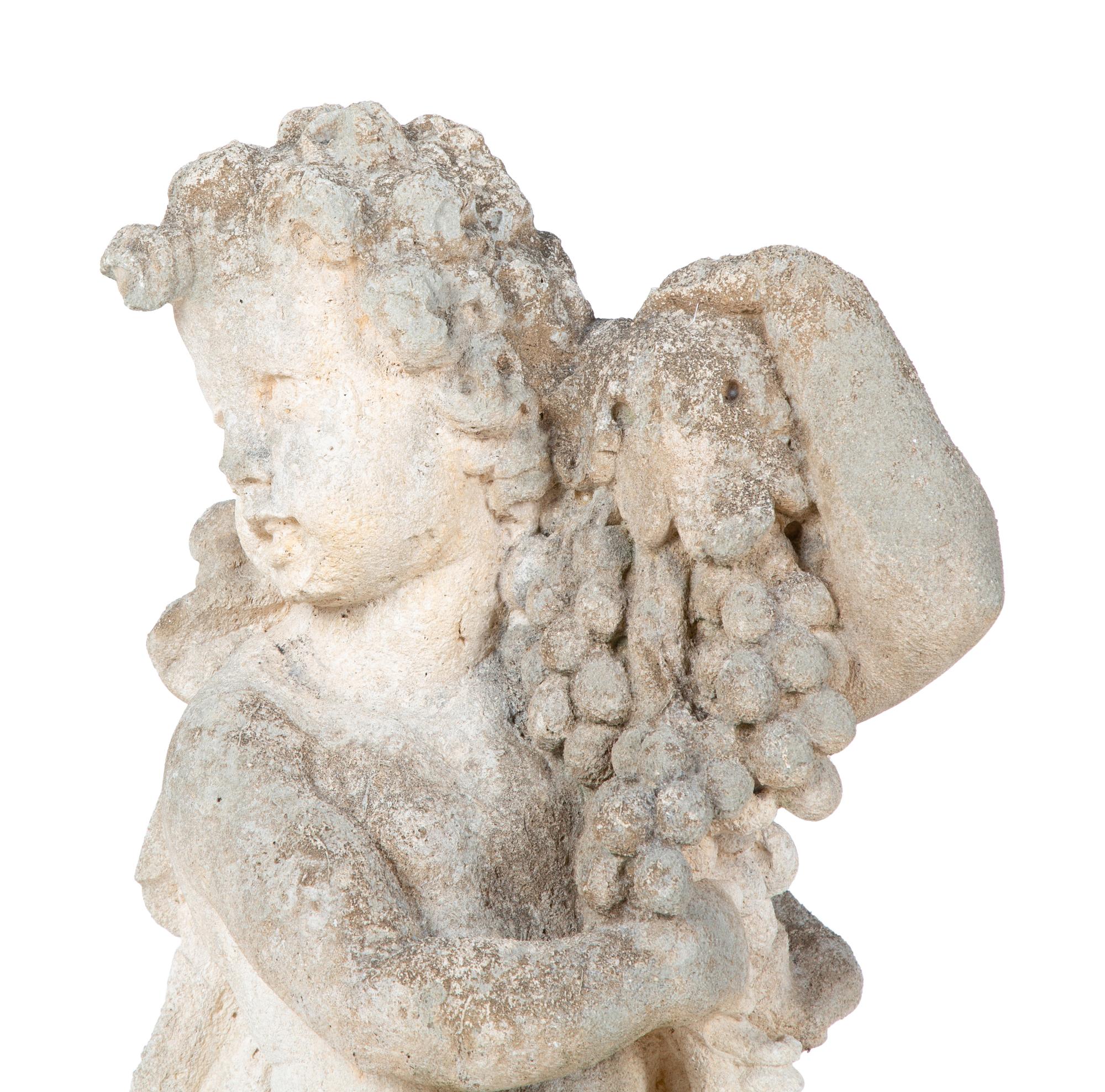 A Cast Stone Figure of Cherub Holding Grapes — 20TH CENTURY