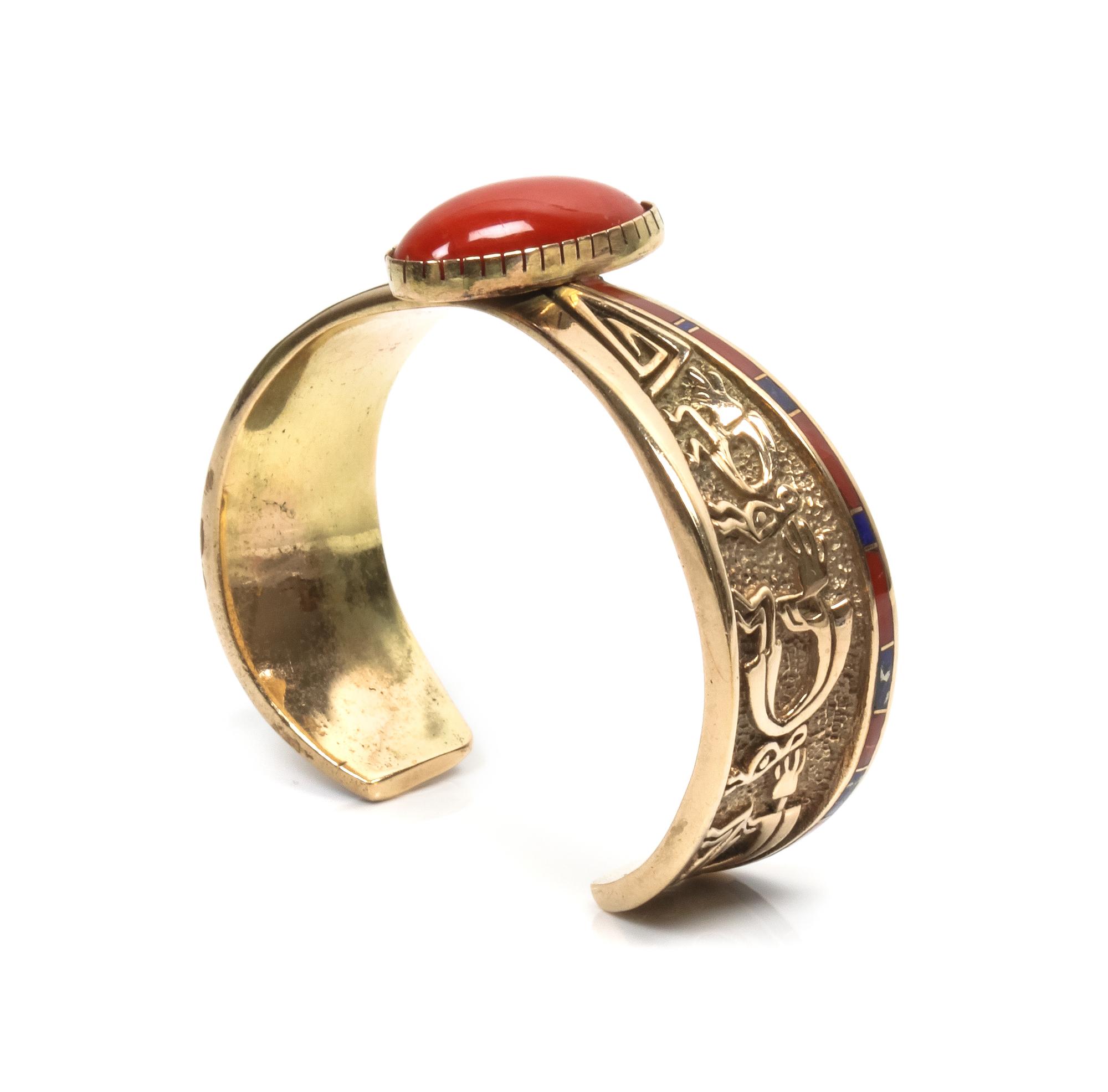 An Isleta/ Navajo Gold, Coral and Lapis Bracelet, Attributed to Andy Lee Kirk Length 4 3/4 x opening 1 x width 7/8 inches.