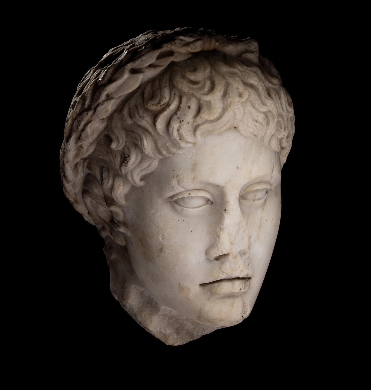 A Roman Marble Head of a Youth Wearing a Laurel Wreath