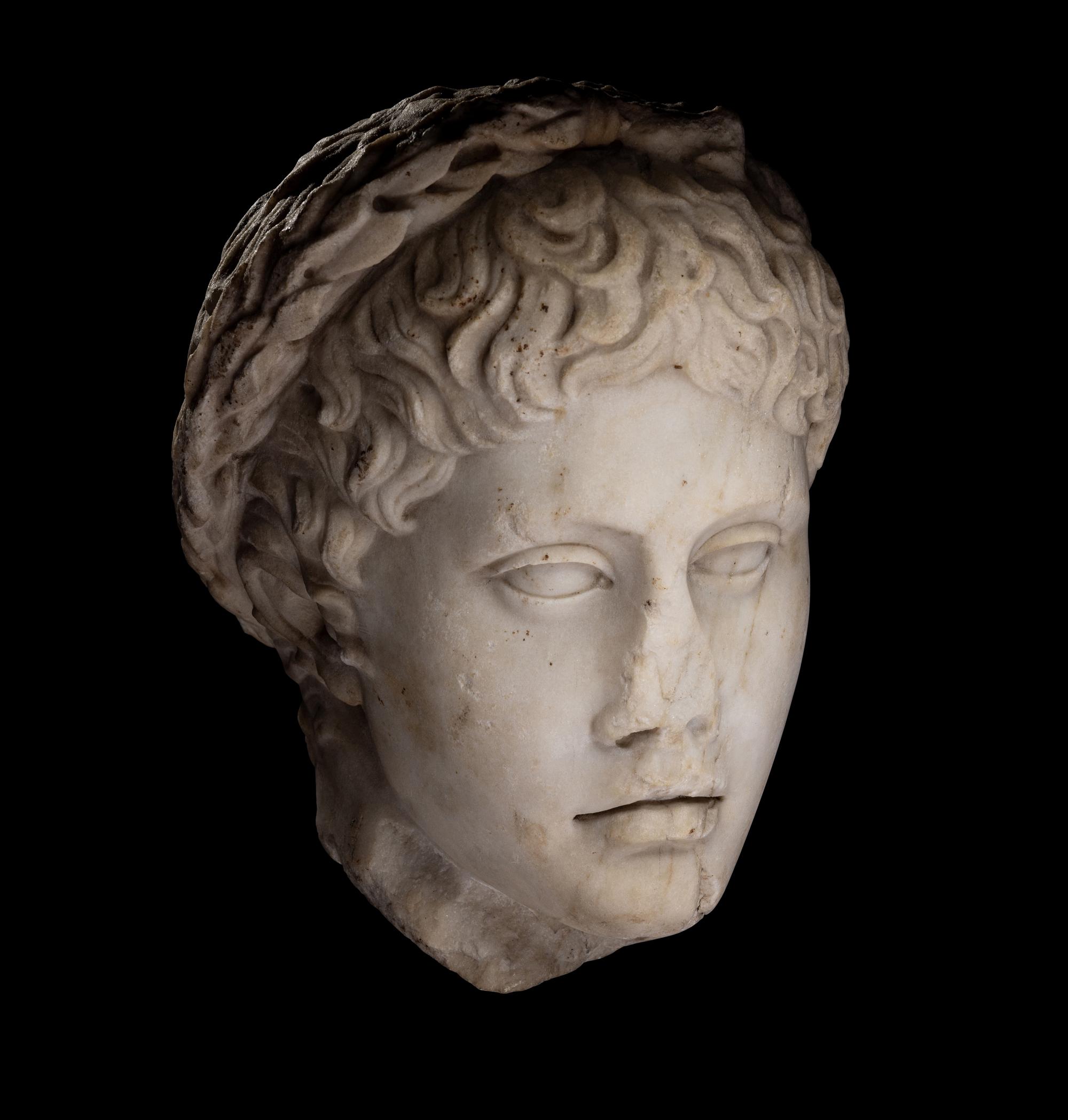 A Roman Marble Head of a Youth Wearing a Laurel Wreath