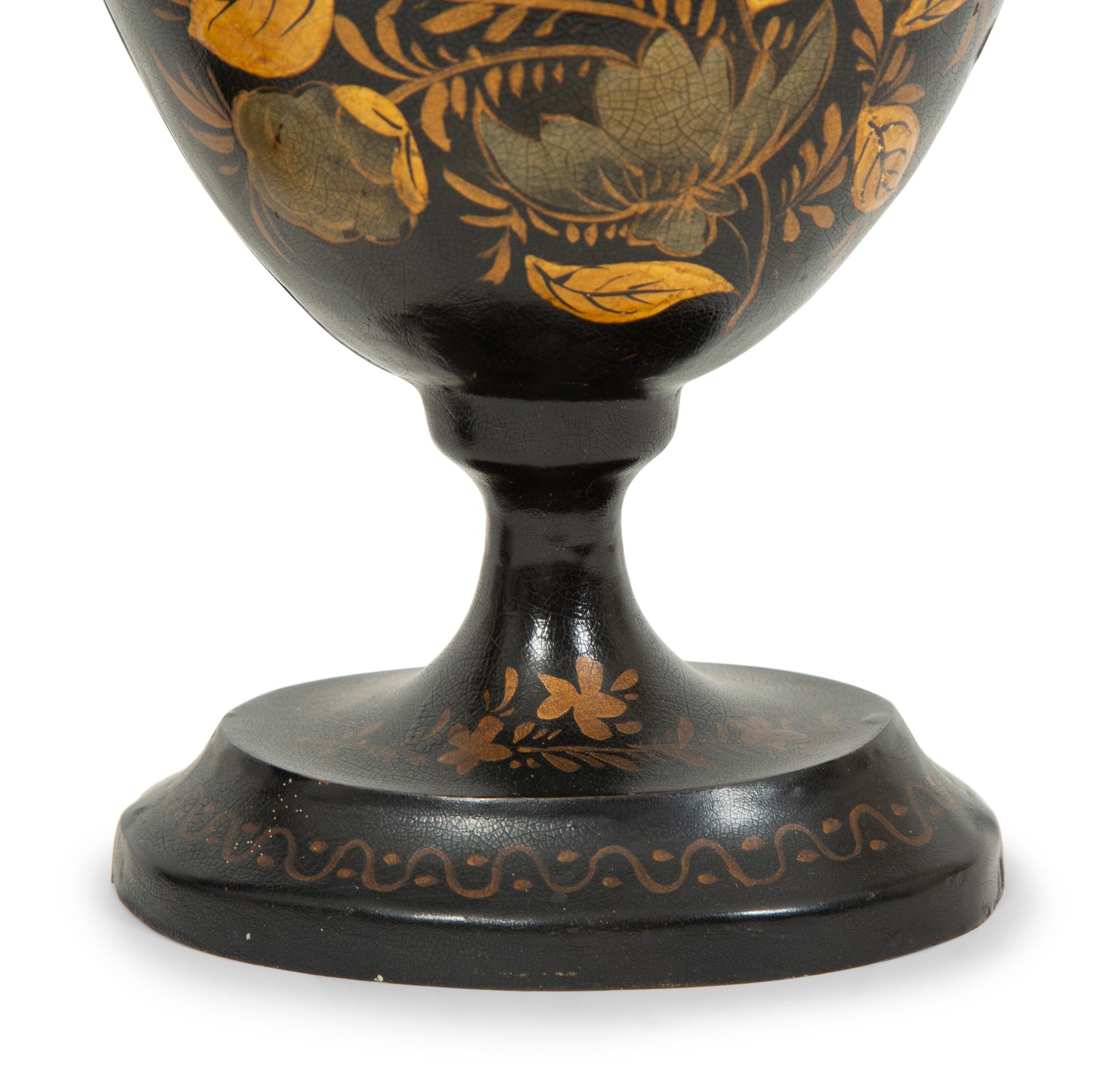 A Pair of Regency Style Black and Gilt Decorated Tole Covered Urns
