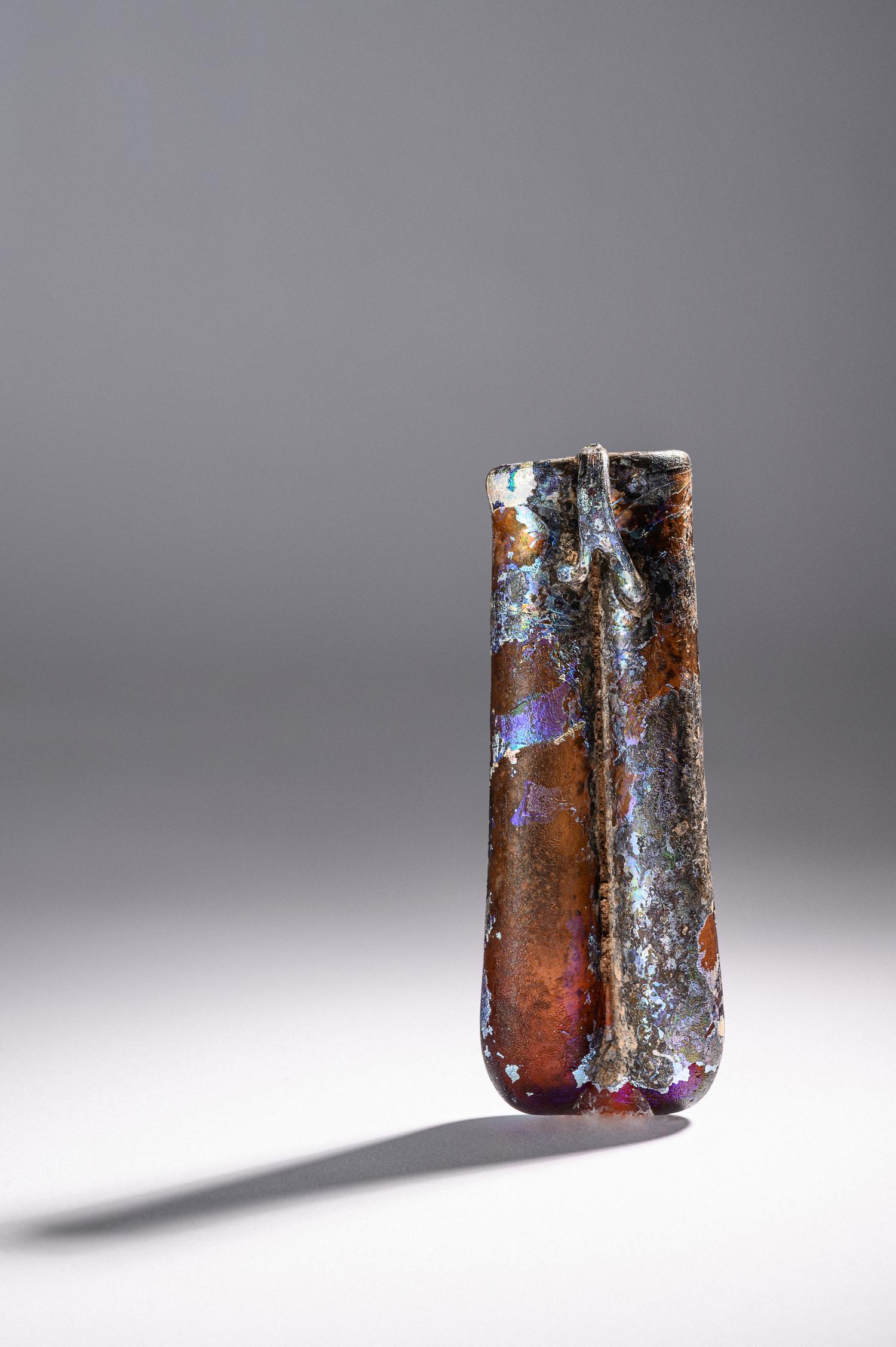 A Roman Purple Glass Double Unguentarium — .