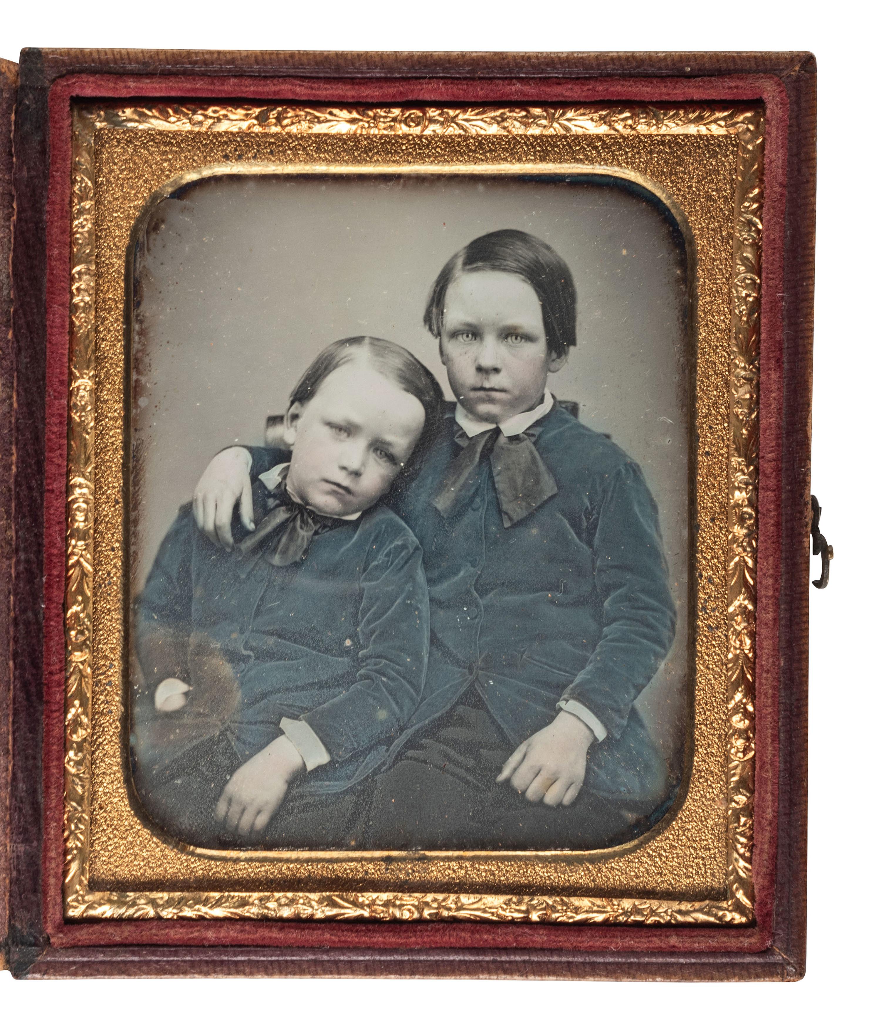 [EARLY PHOTOGRAPHY]. Sixth plate daguerreotype portrait of a pair of young brothers wearing blue jackets and embracing in a loving pose.
