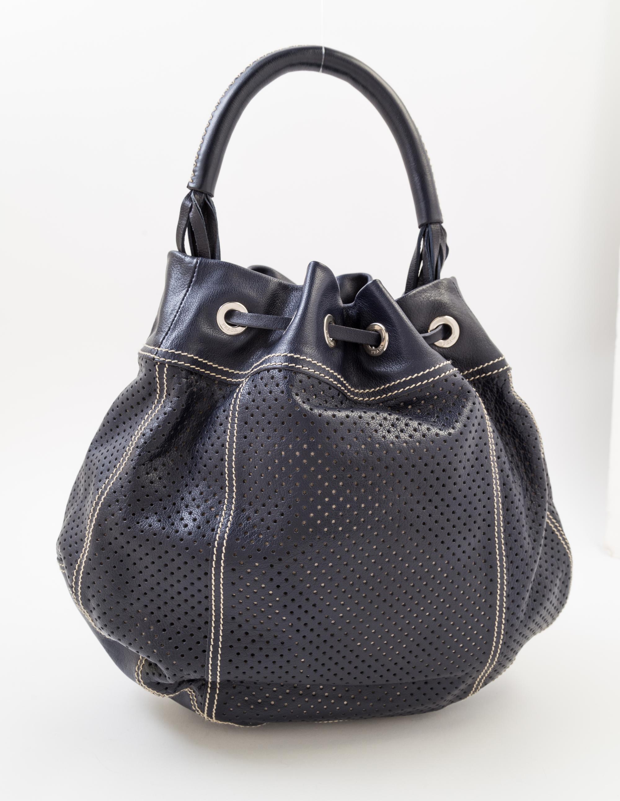 A Prada Navy Perforated Leather Bucket Bag, 13" x 12" x 4"; Handle drop: 4.5".