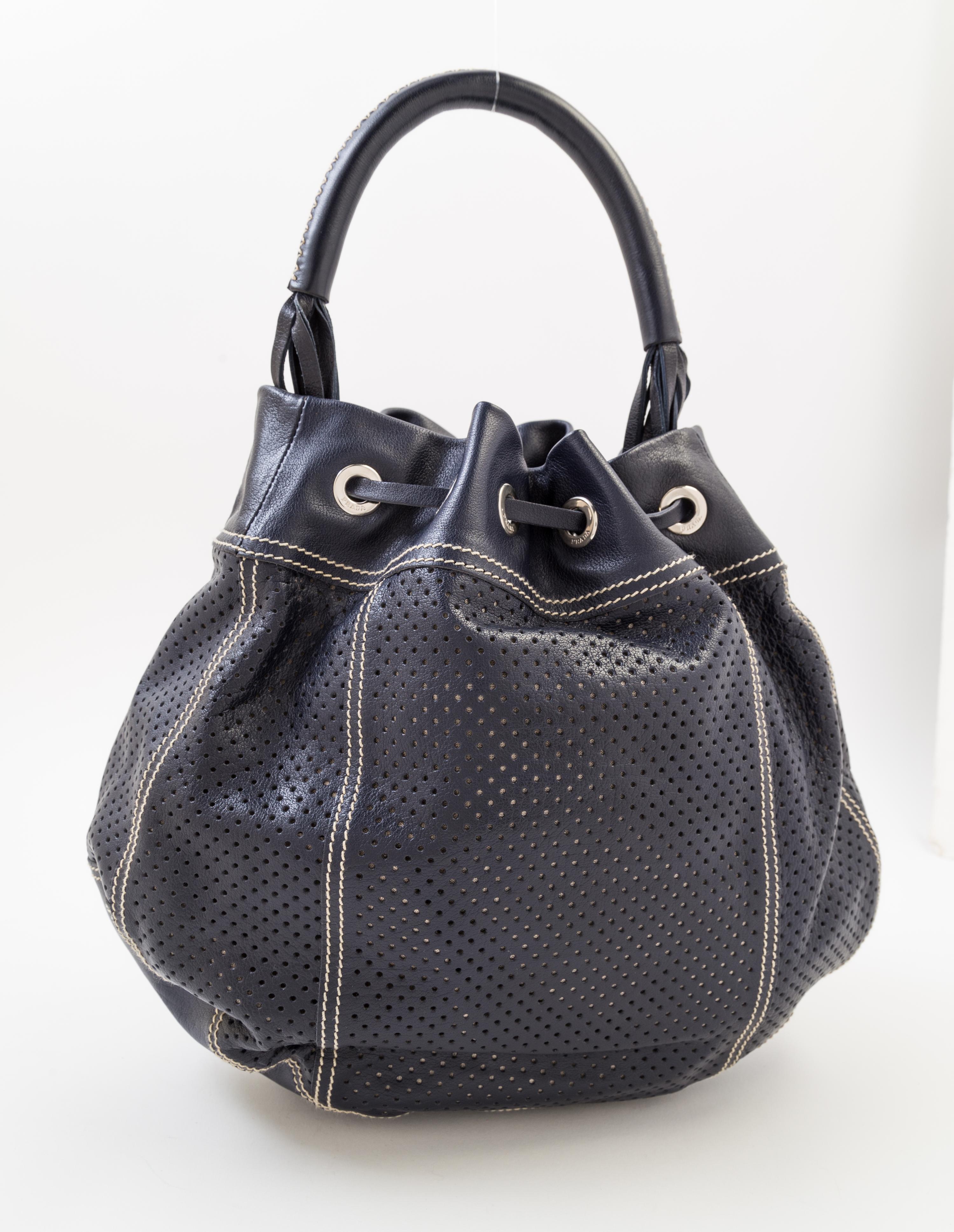 A Prada Navy Perforated Leather Bucket Bag, 13" x 12" x 4"; Handle drop: 4.5".