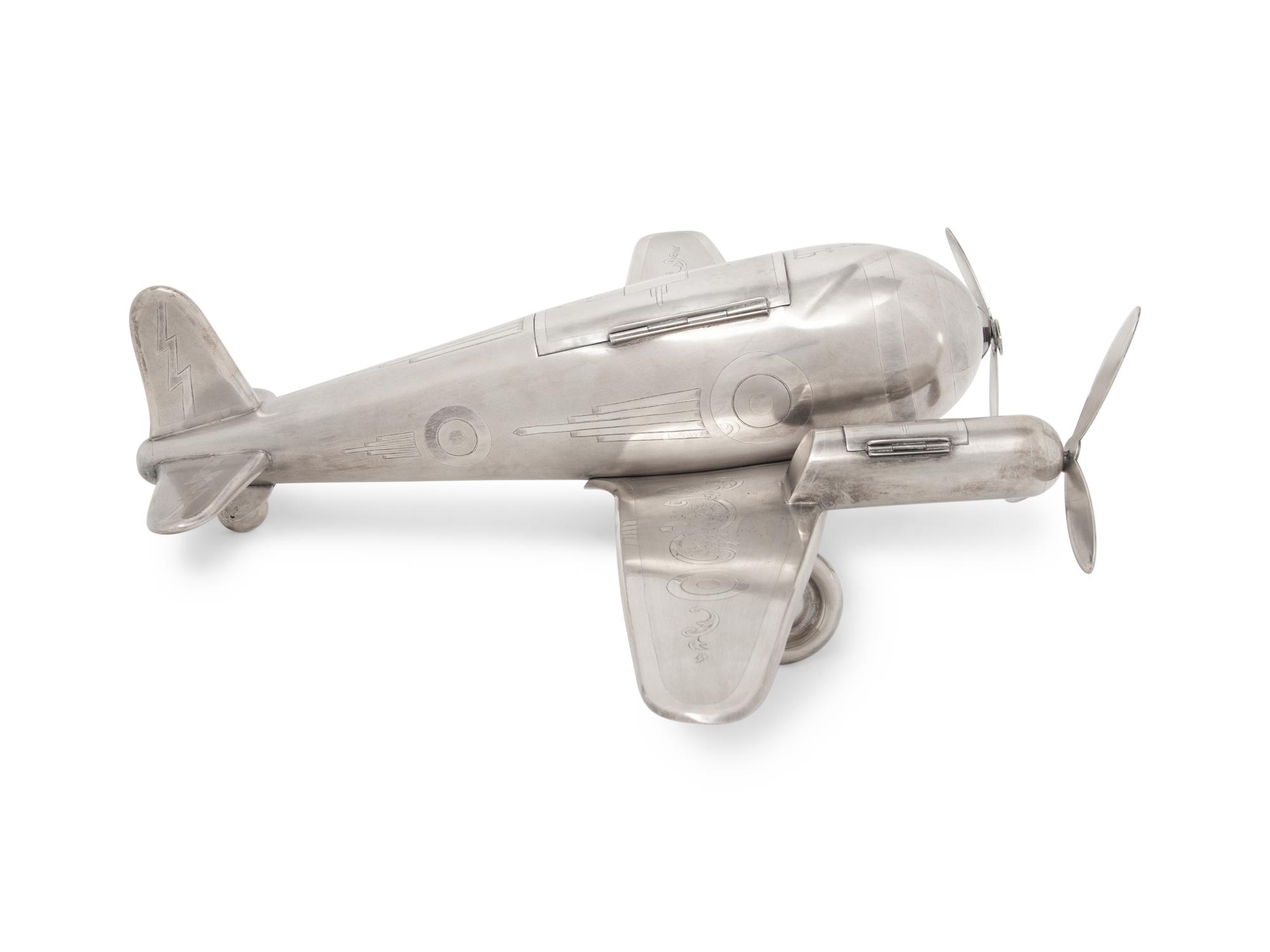 A Large Silvered Metal Airplane-Form Table Top Smoking Set
