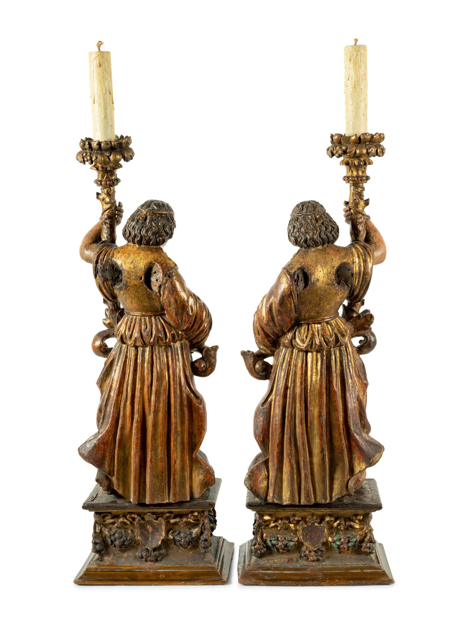 A Pair of Continental Carved, Painted and Parcel Gilt Figural Pricket Sticks