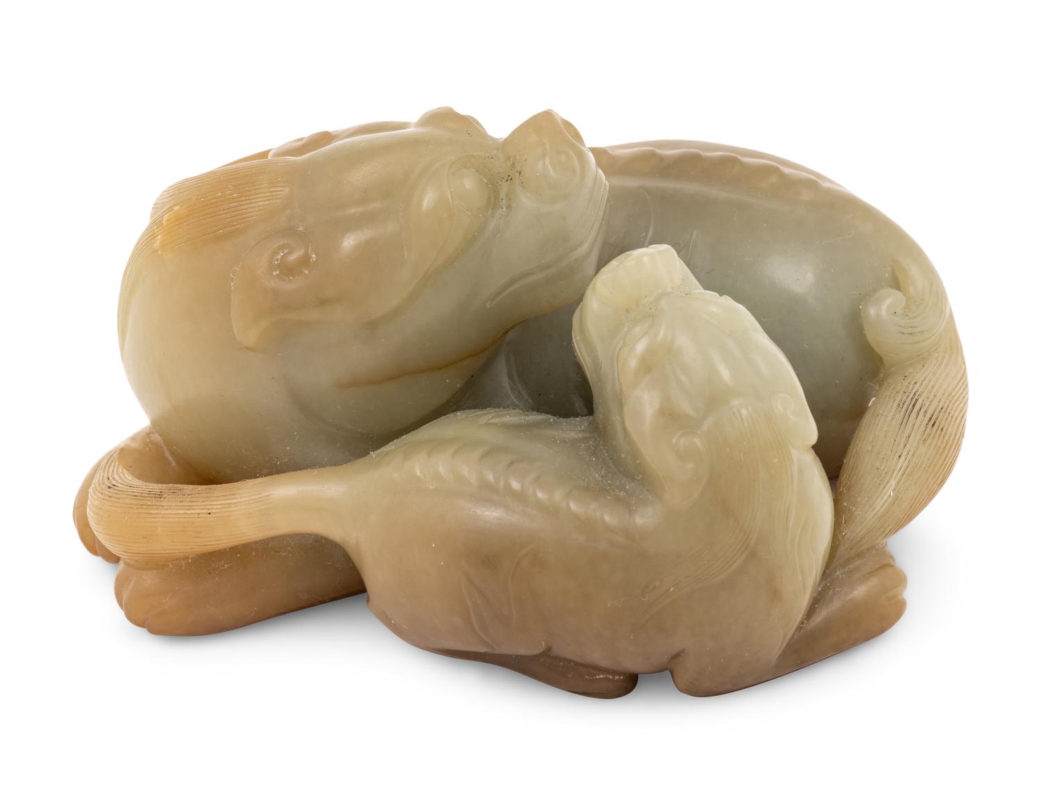 A Chinese Celadon and Russet Jade Carving of Two Mythical Beasts