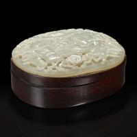 A Chinese carved celadon jade "Elephant" plaque mounted as a box 木盒嵌太平有象浮雕玉板