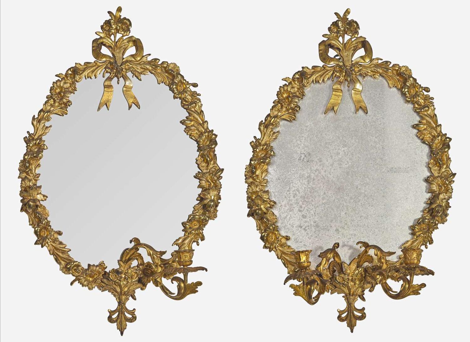 A pair of gilt bronze oval mirrors, 19th century
