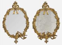 A pair of gilt bronze oval mirrors, 19th century