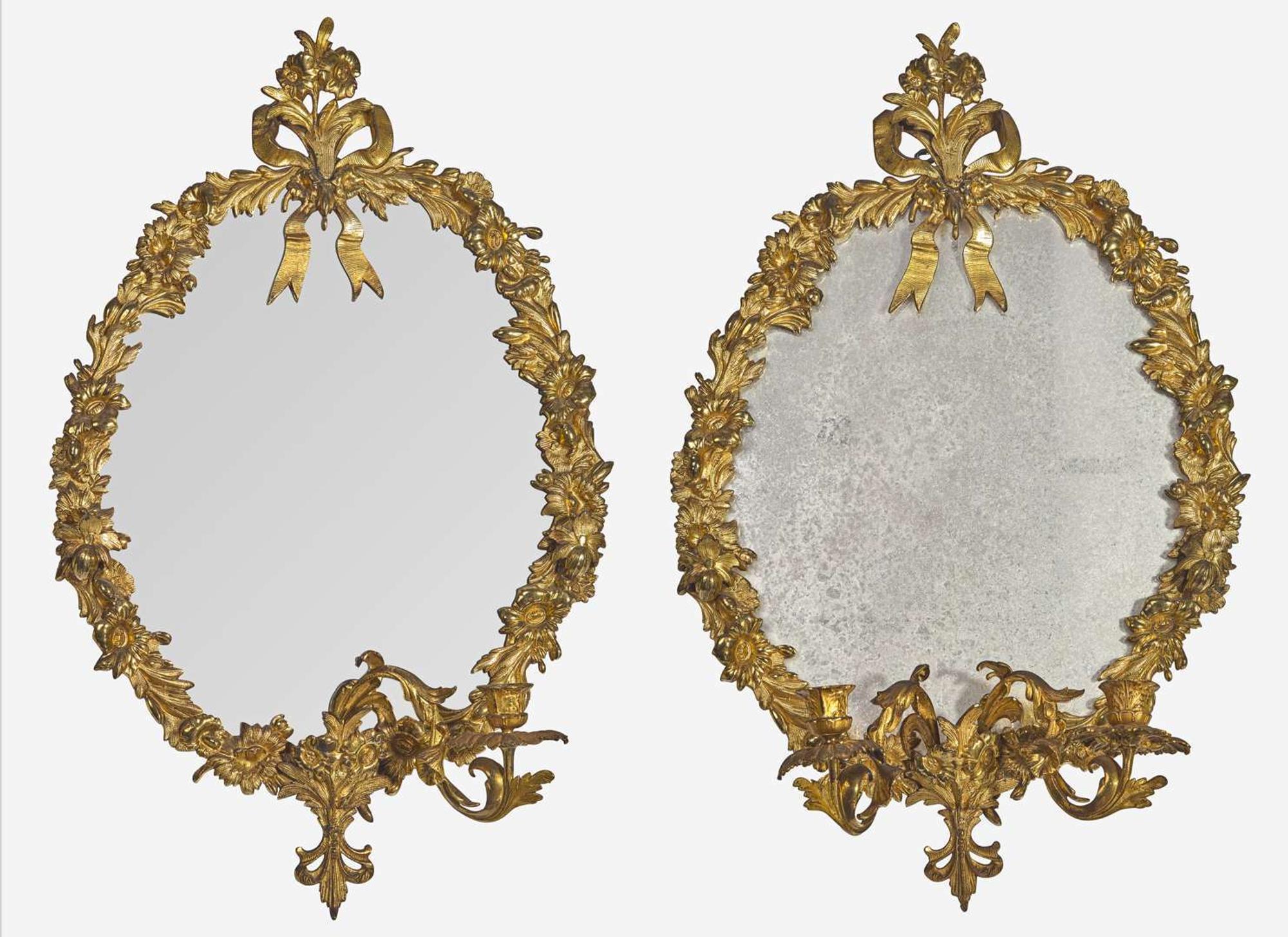 A pair of gilt bronze oval mirrors, 19th century