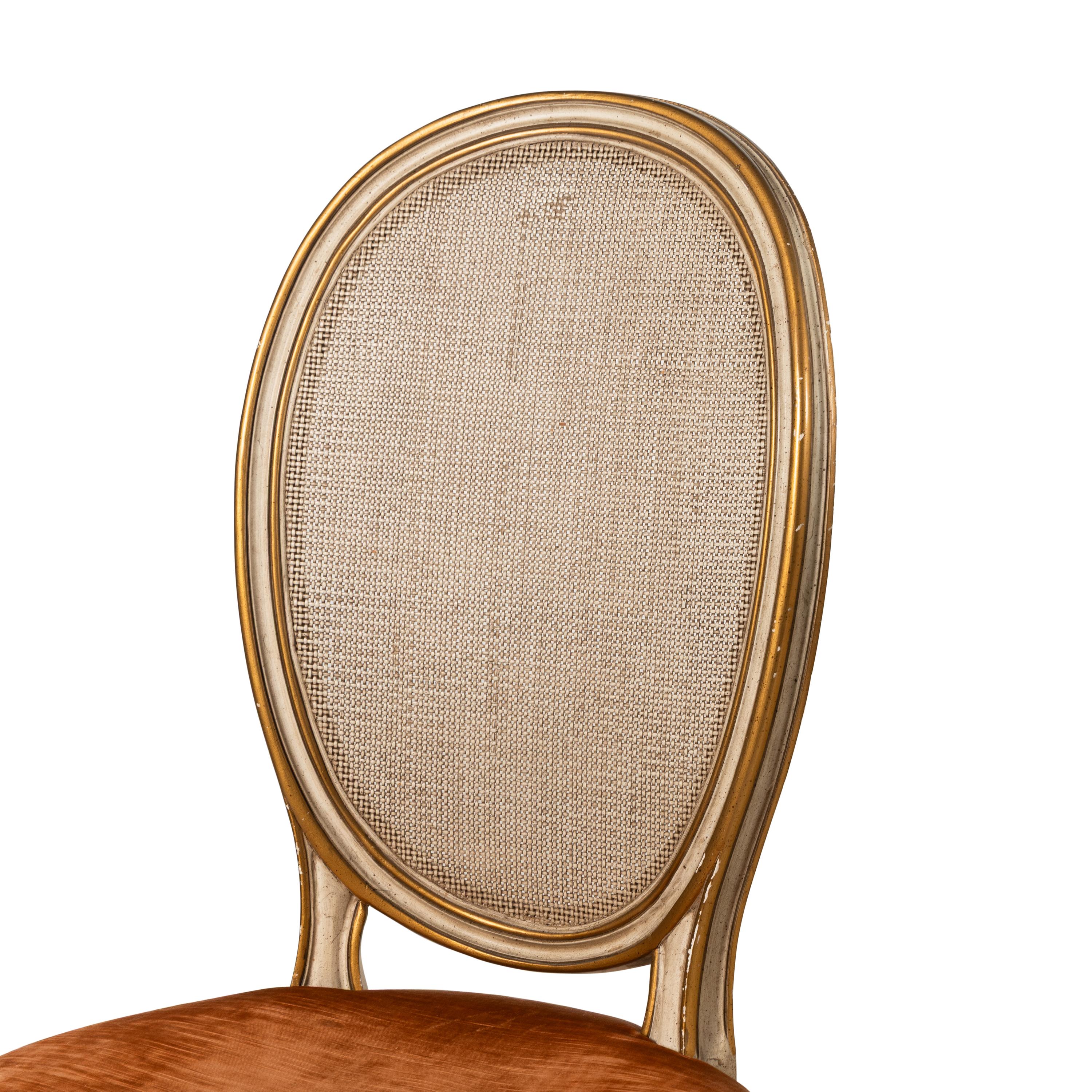 A Set of Eight Louis XVI Style Crème-Painted and Parcel Gilt Dining Chairs