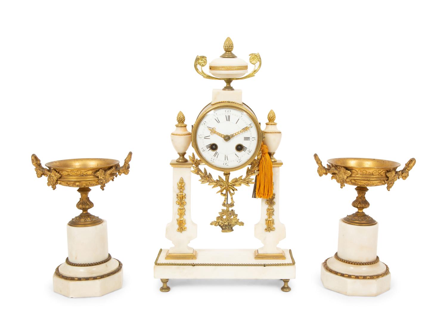 A French Gilt Bronze and Marble Mantel Clock with an Associated Pair of Urns
