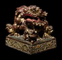 A Chinese Red and Gilt Lacquered Stone 'Buddhist Lion' Paperweight
