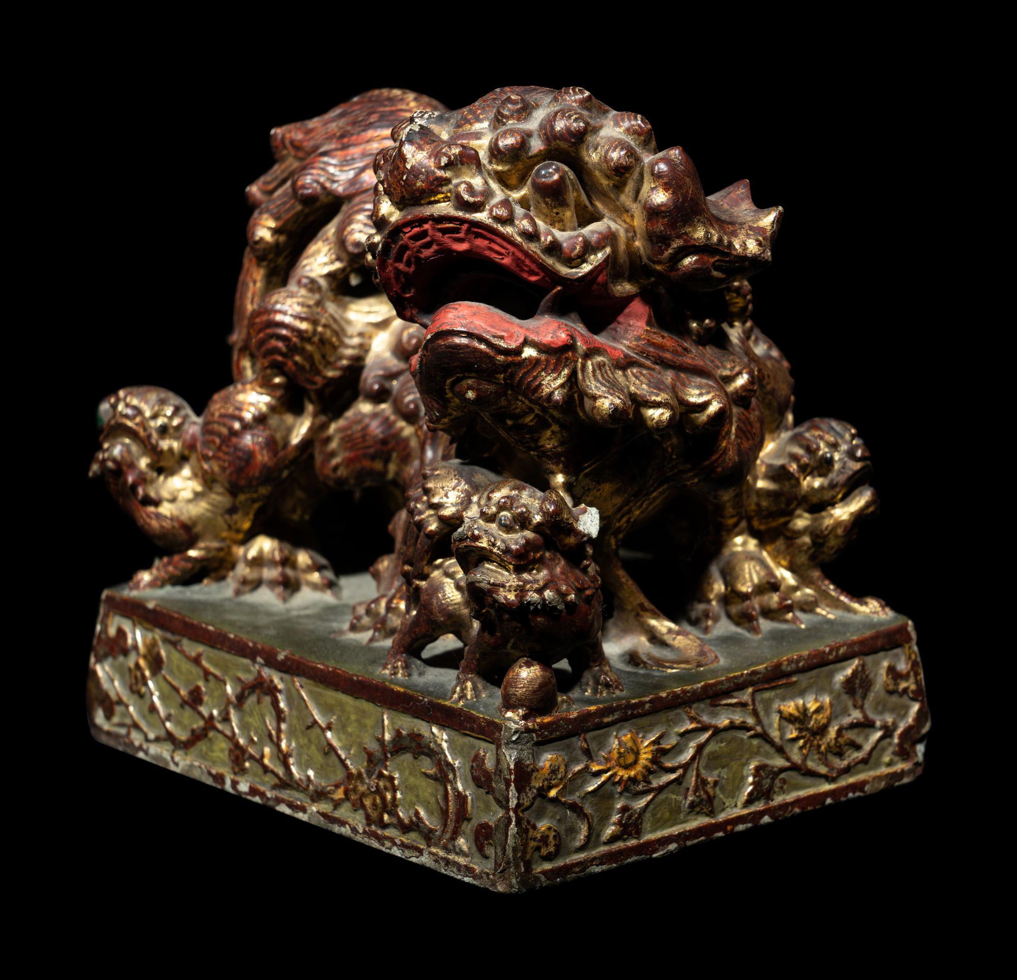 A Chinese Red and Gilt Lacquered Stone 'Buddhist Lion' Paperweight
