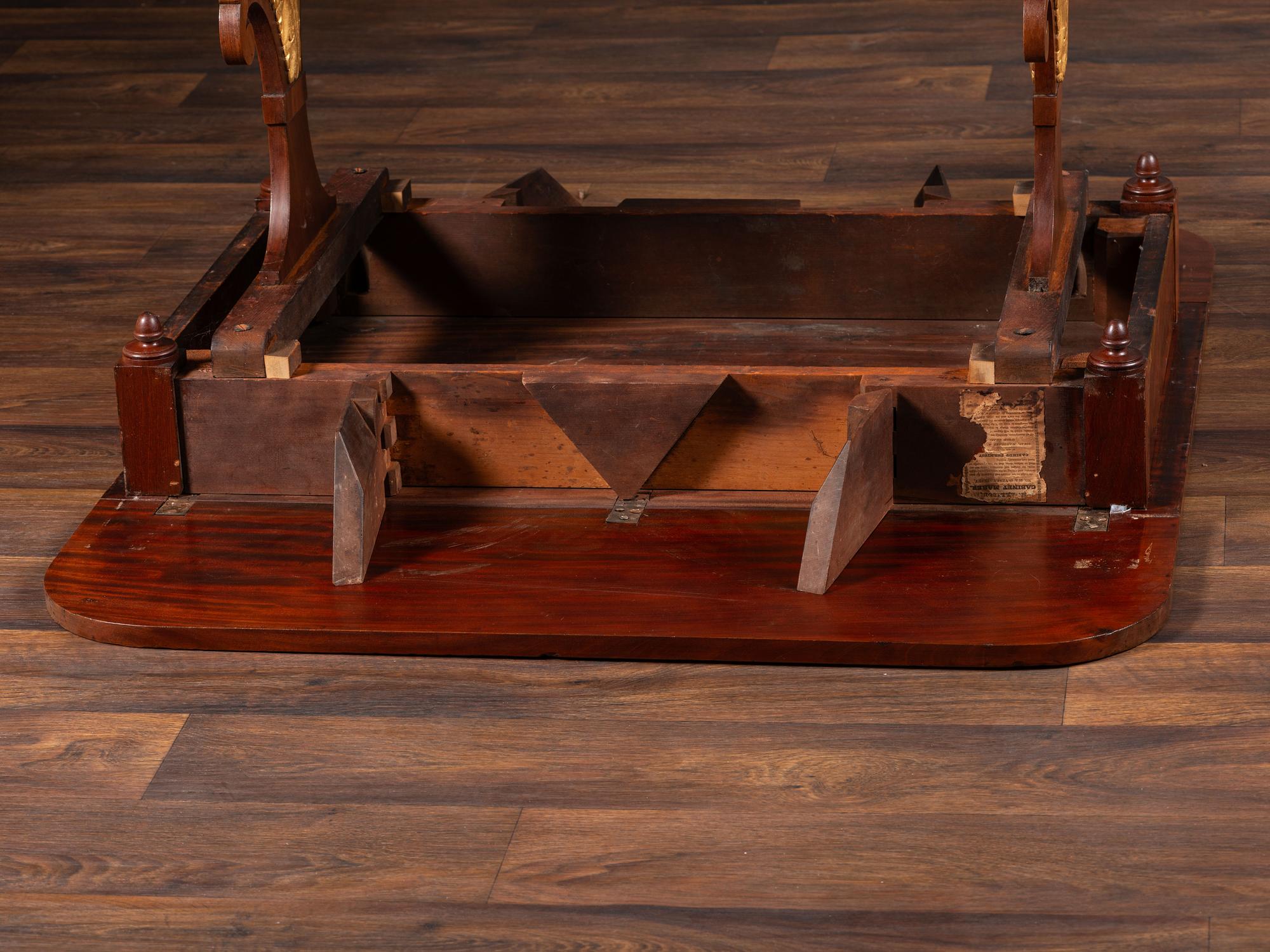 A Classical Parcel Gilt and Ebonized, Figured Mahogany Paw-Foot Drop-Leaf Table