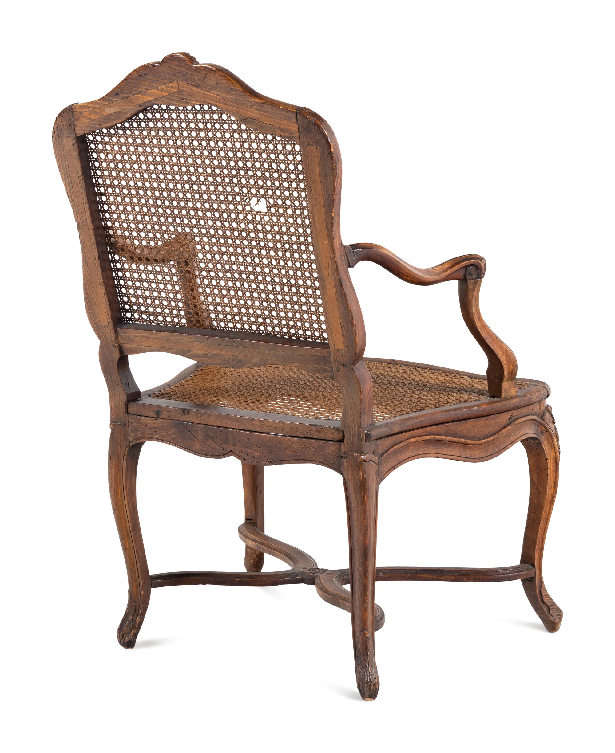 A Régence Carved Walnut and Caned Fauteuil