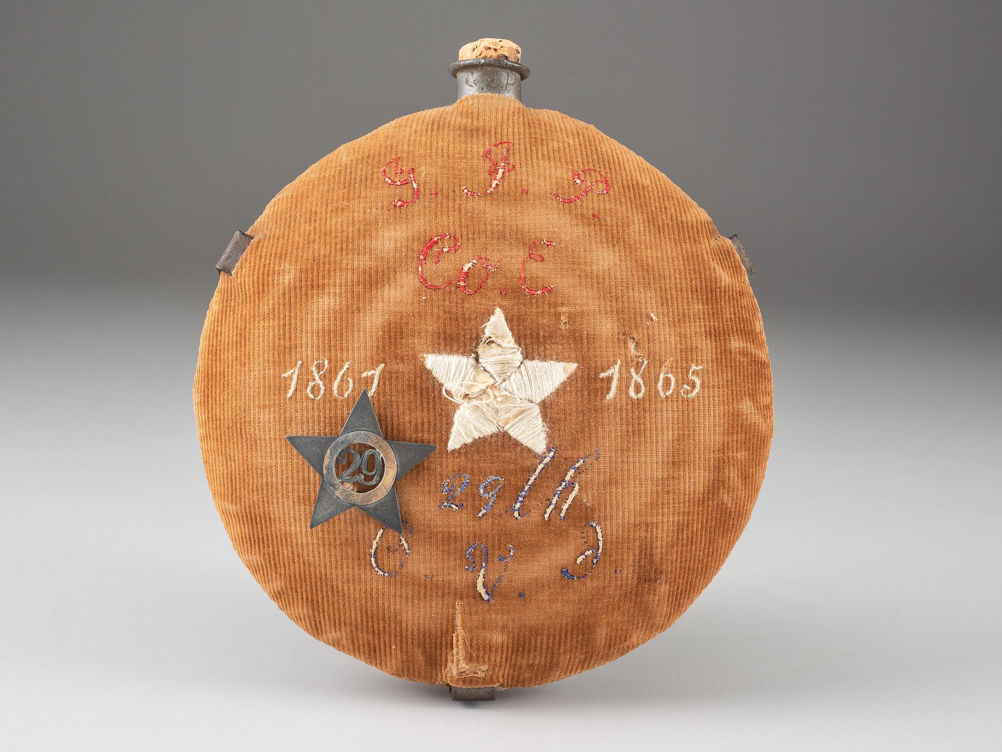 [CIVIL WAR]. A group of 3 items identified to George J. Putney, Company E, 29th Ohio Infantry, comprised of a silver corps badge engraved with battle honors, embellished canteen, and book taken from wreckage at Bristoe Station.