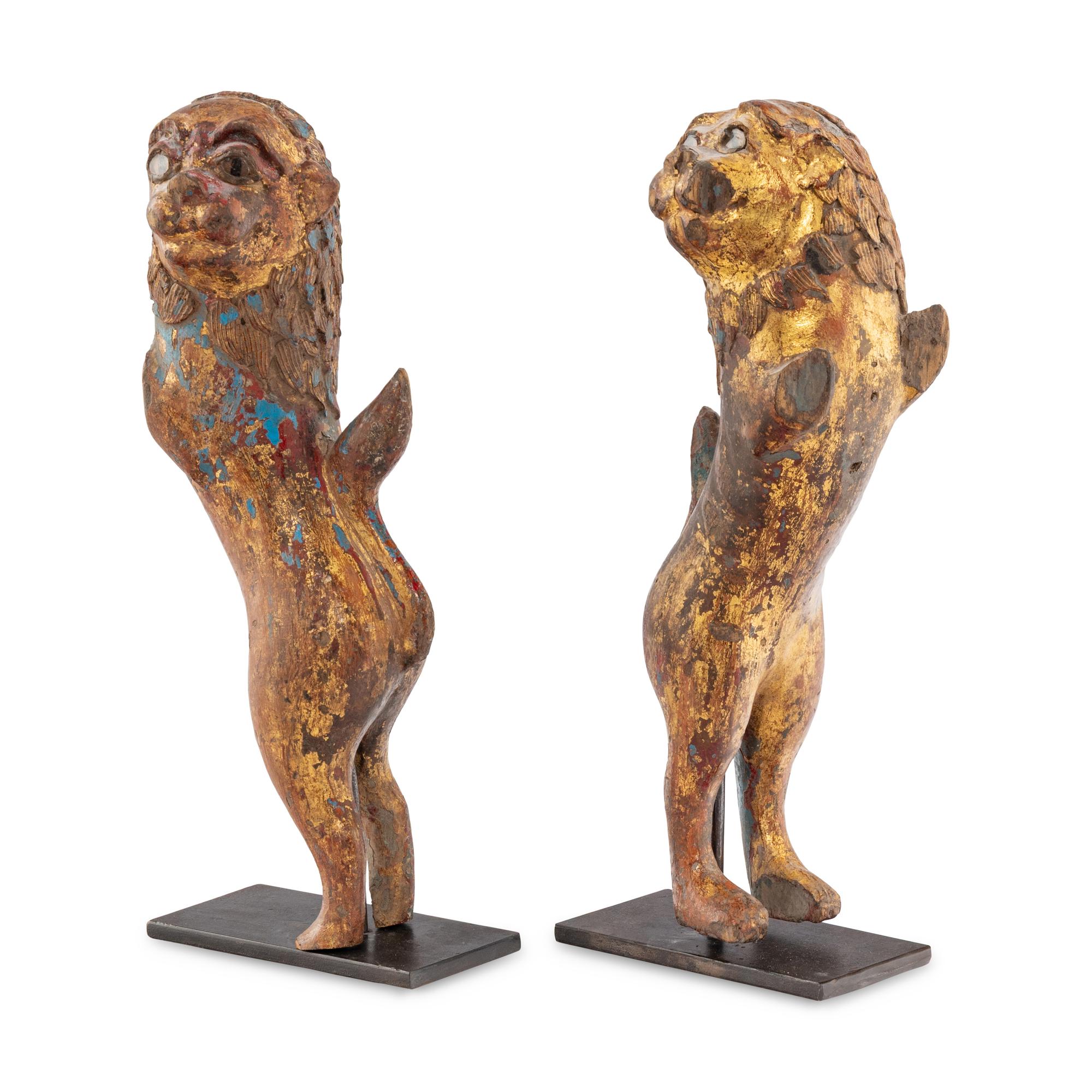 A Pair of Parcel-Gilt and Polychrome Decorated Lion-Form Crest Supporters