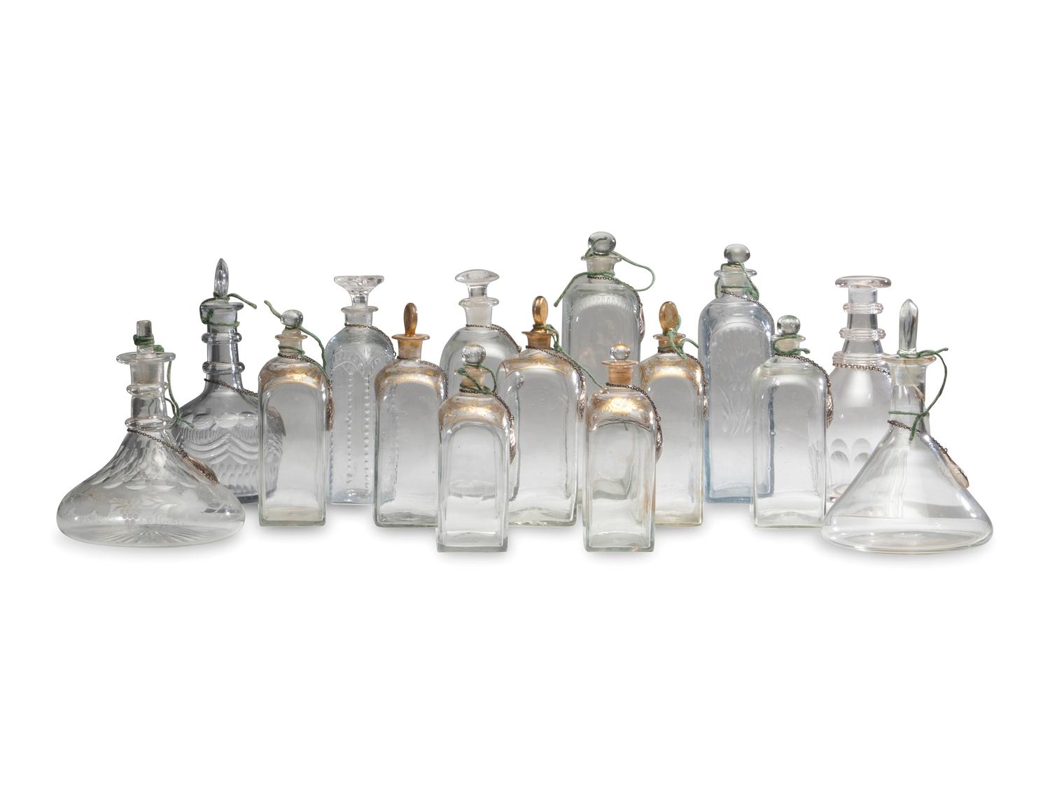 Fifteen Glass Decanters with English Shell-Form Silver Bottle Tags