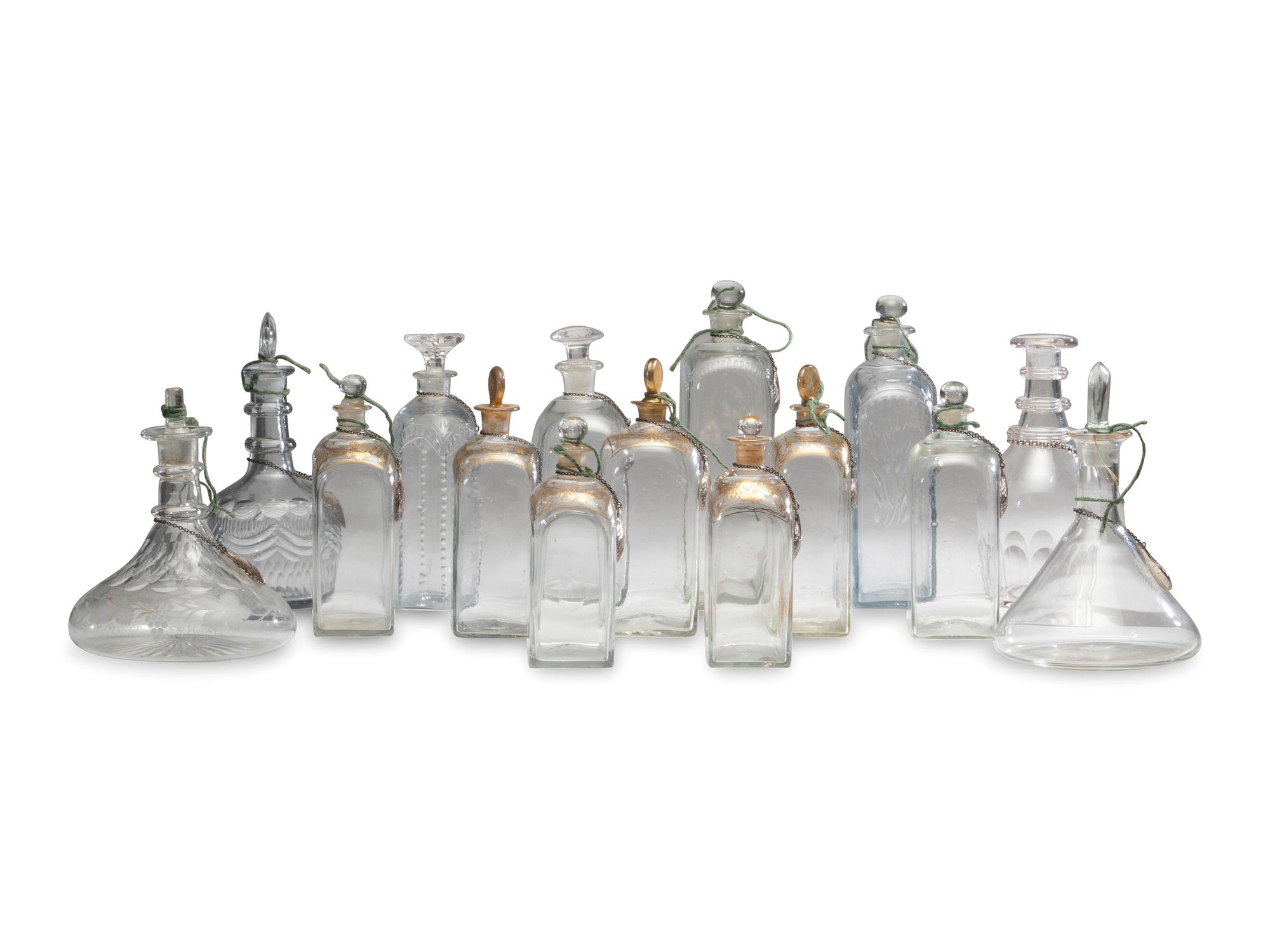 Fifteen Glass Decanters with English Shell-Form Silver Bottle Tags
