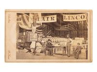 [POLITICS -- LINCOLN]. CDV of a Sanitary Fair booth with numerous barrels, farm implements, and political banners for BLAIR and LINCOLN on display. St. Louis, MO: Scholten, ca 1860s.