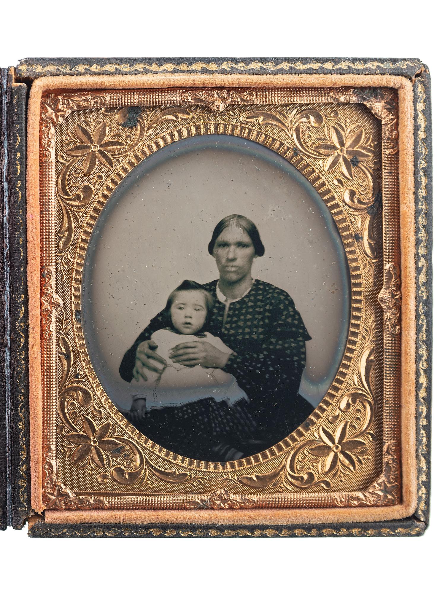 [EARLY PHOTOGRAPHY]. Sixth plate ruby ambrotype of an African American or mixed race woman holding a white child.